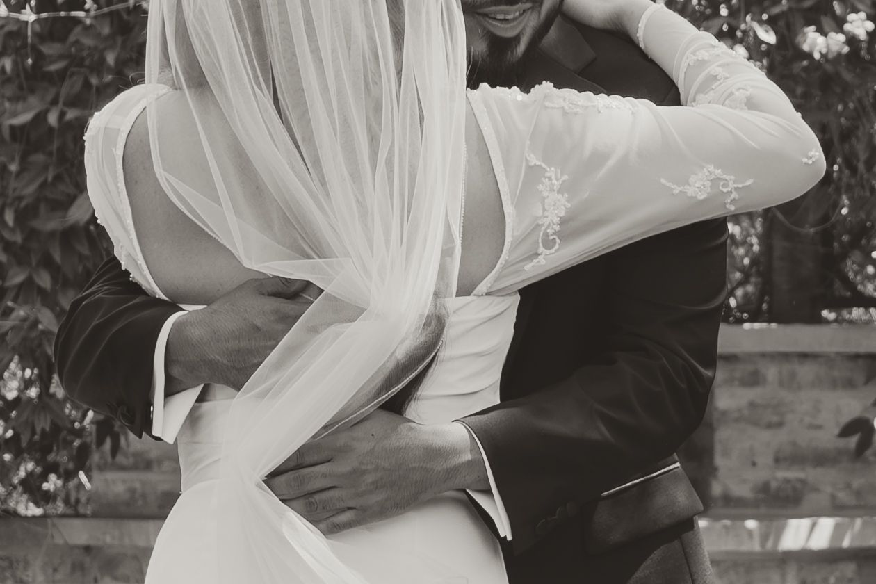 A romantic black and white photo series showing a couple embracing and dancing together in formal wedding attire. Wedding Photographer DFW