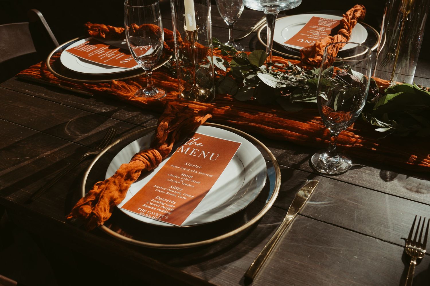 Elegant table settings with copper accents, white plates, and menus at a formal dinner event. Wedding Photographer DFW