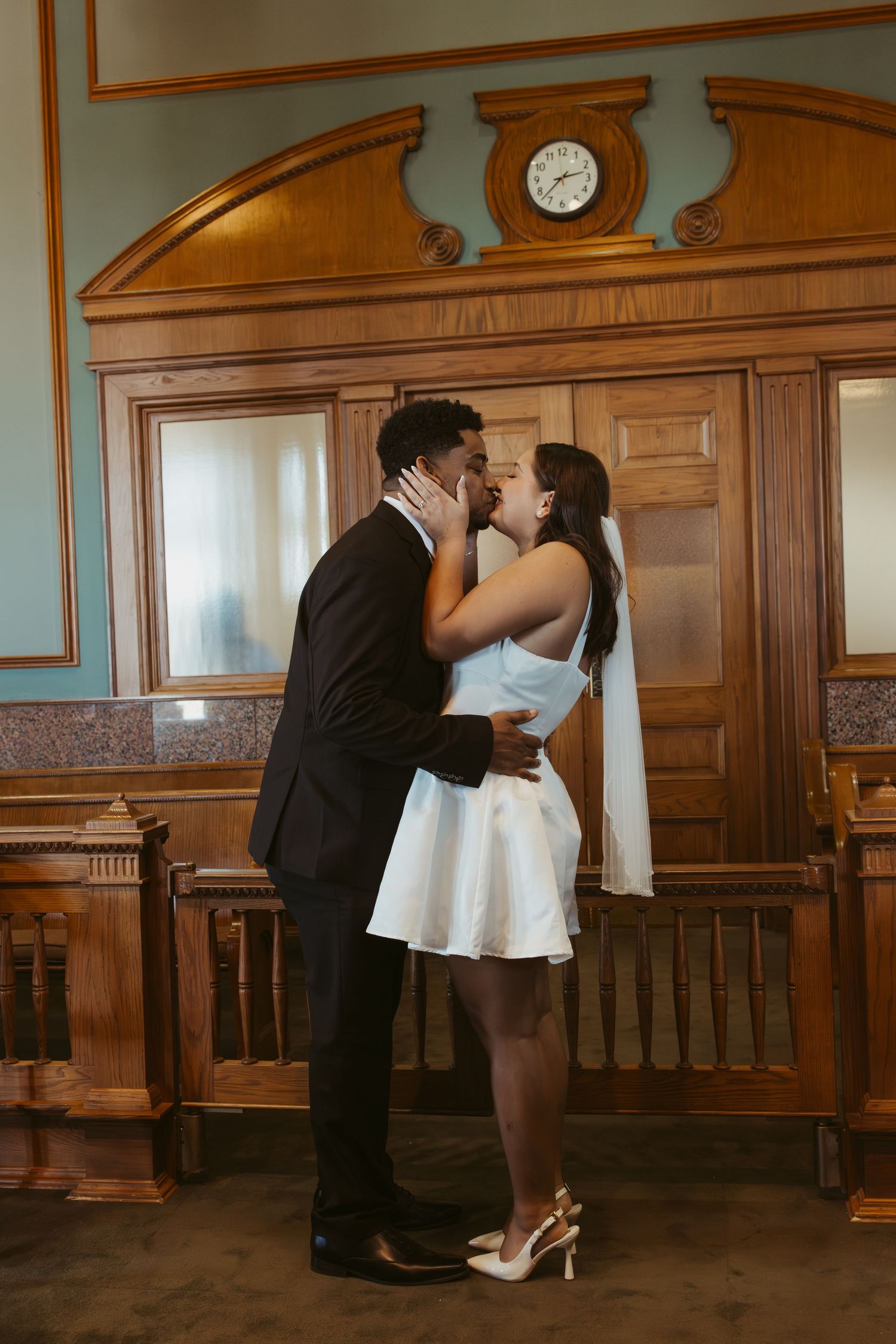 A romantic scene in a wood-paneled courtroom with vintage architectural details. Wedding Photographer DFW