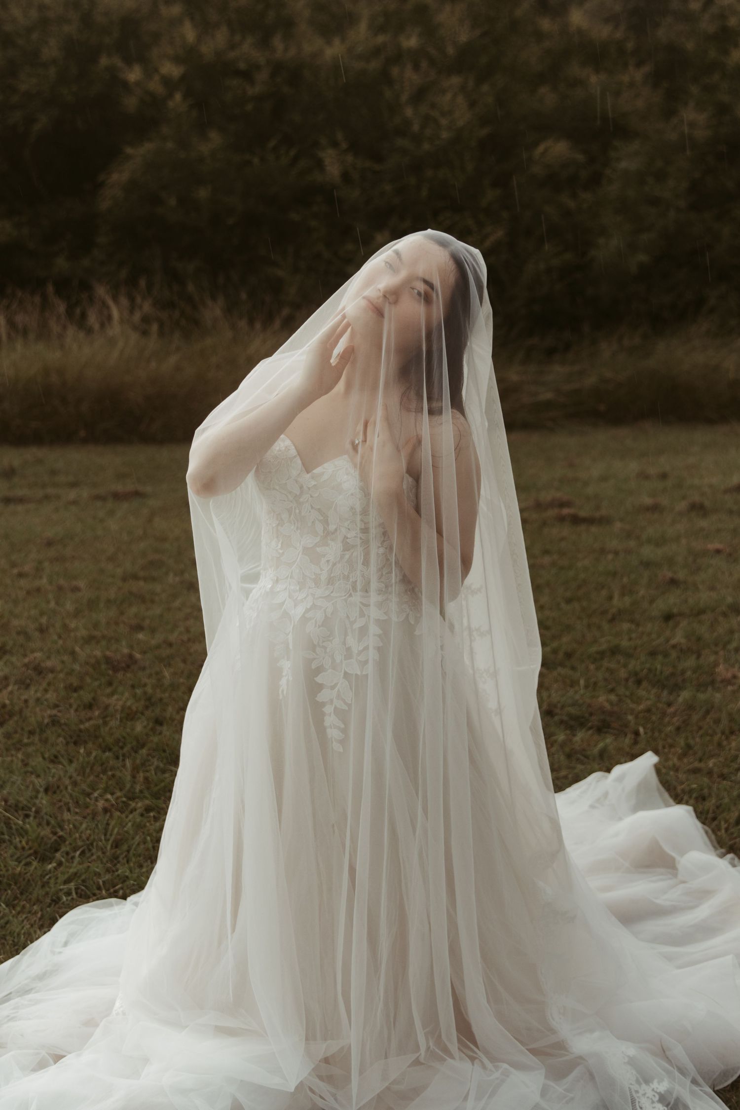 Ethereal bridal portrait series showing flowing white wedding dress and veil against a dark outdoor backdrop.