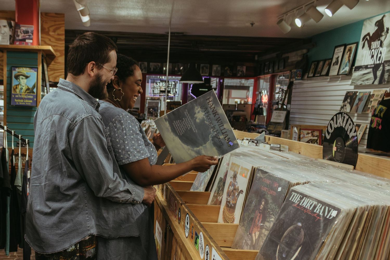Two people browse through vinyl records together at a vintage record store.