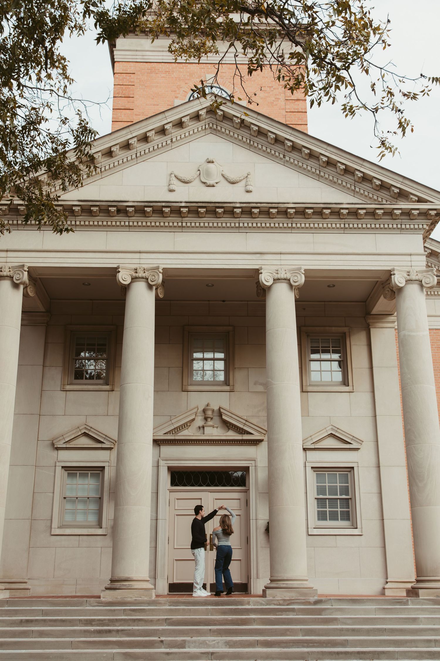 Elegant neoclassical building facade with white columns and pediment details in warm sunlight. engagement photos Fort Worth