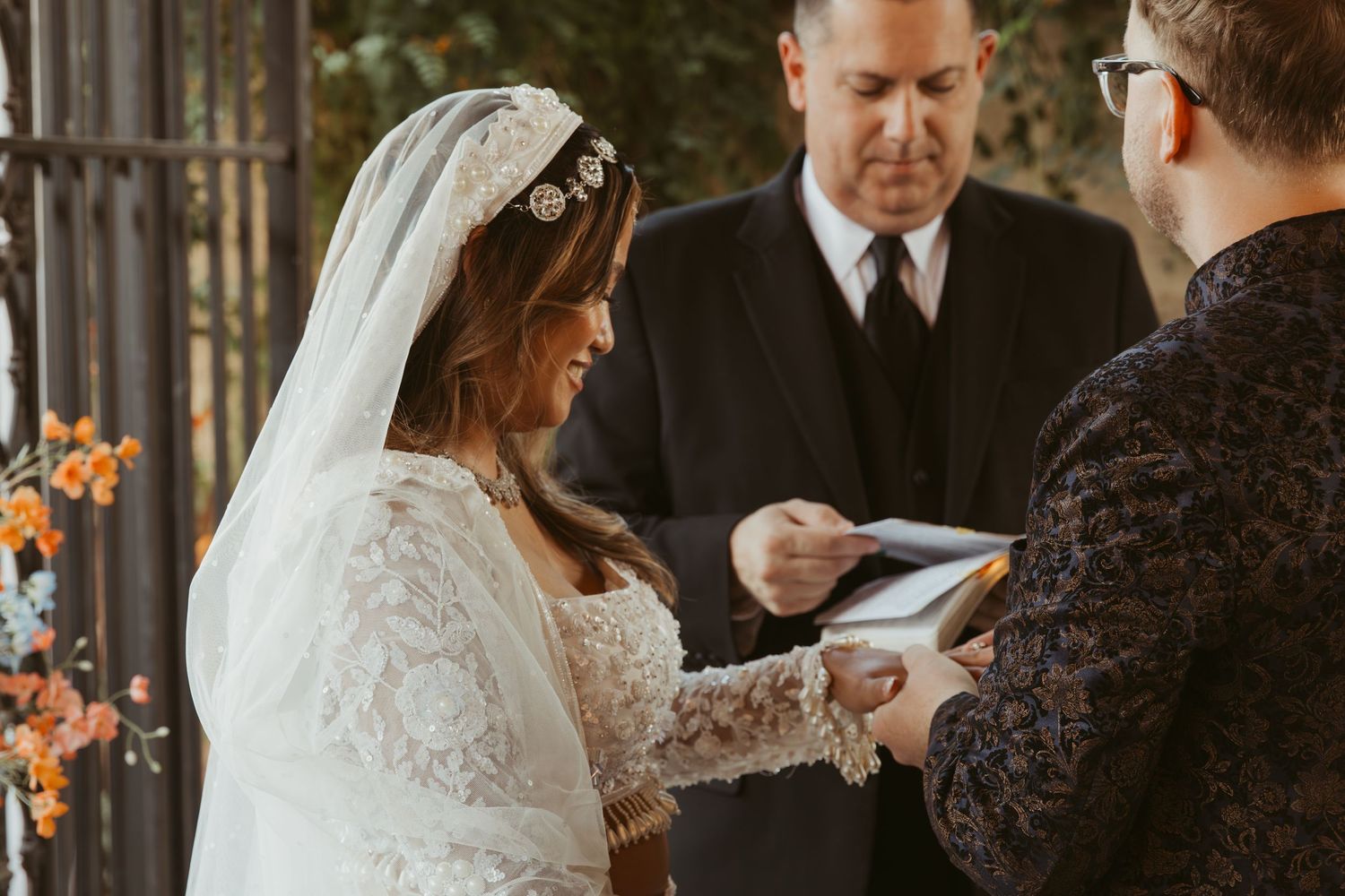Wedding ceremony in progress under an elegant outdoor pavilion.