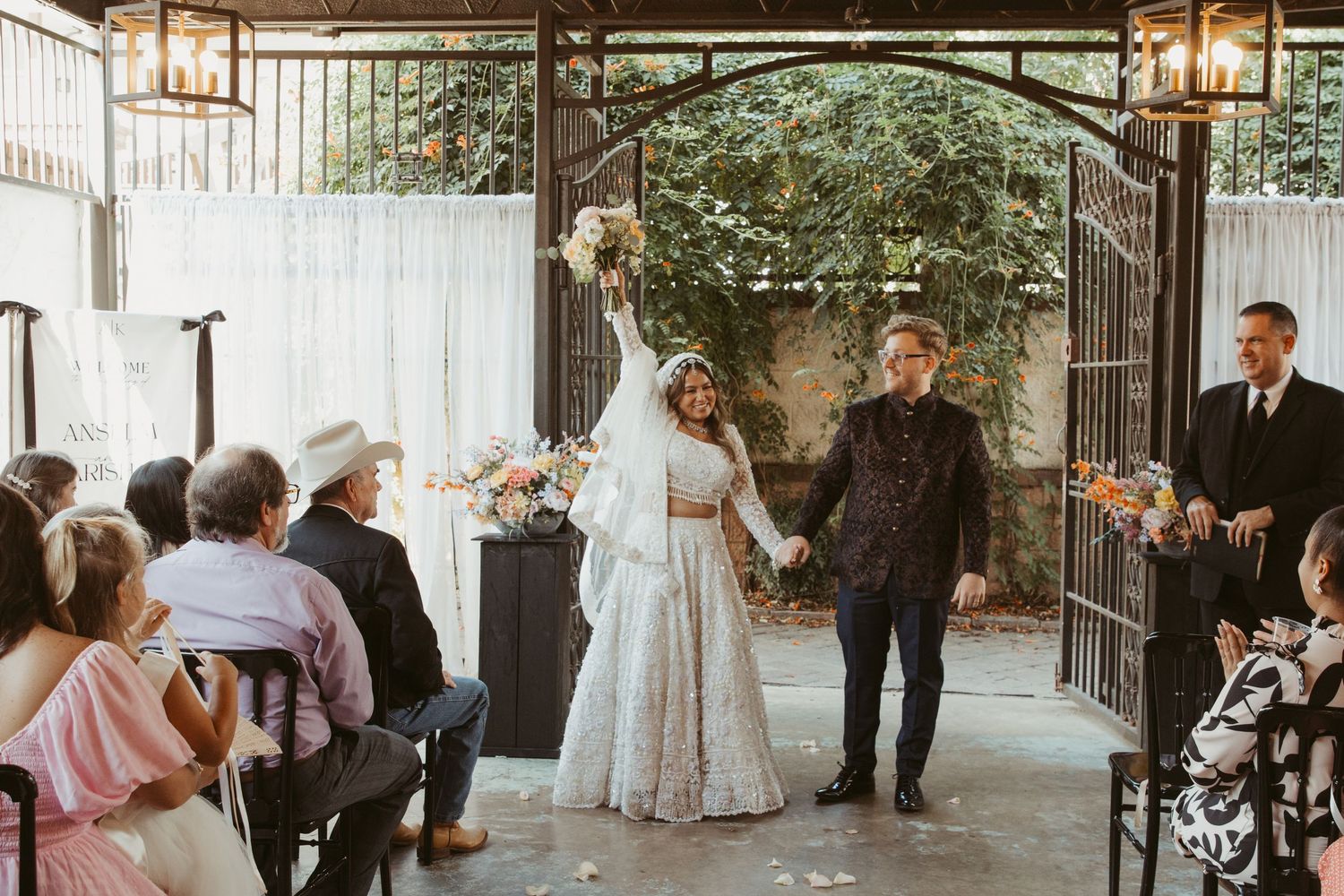 Ceremony celebration in a garden venue with guests watching and floral decorations.