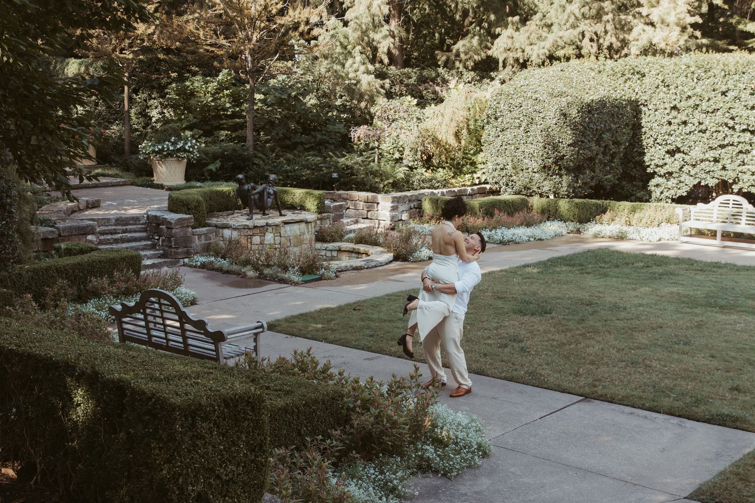 Stone steps and walkways wind through a landscaped garden with lush greenery and natural materials.