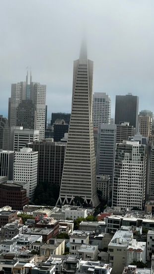 The Transamerica Pyramid skyscraper rises above San Francisco cityscape on a cloudy day.