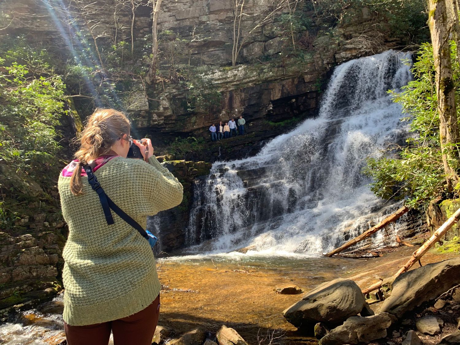 A photographer captures Margarette Falls cascading down rocky cliffs in a scenic East Tennessee forest setting.