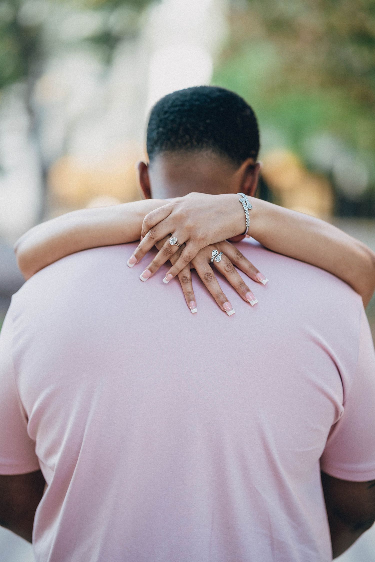 Back view of person in pink t-shirt with someone's hands placed on their shoulders in sequence of images.