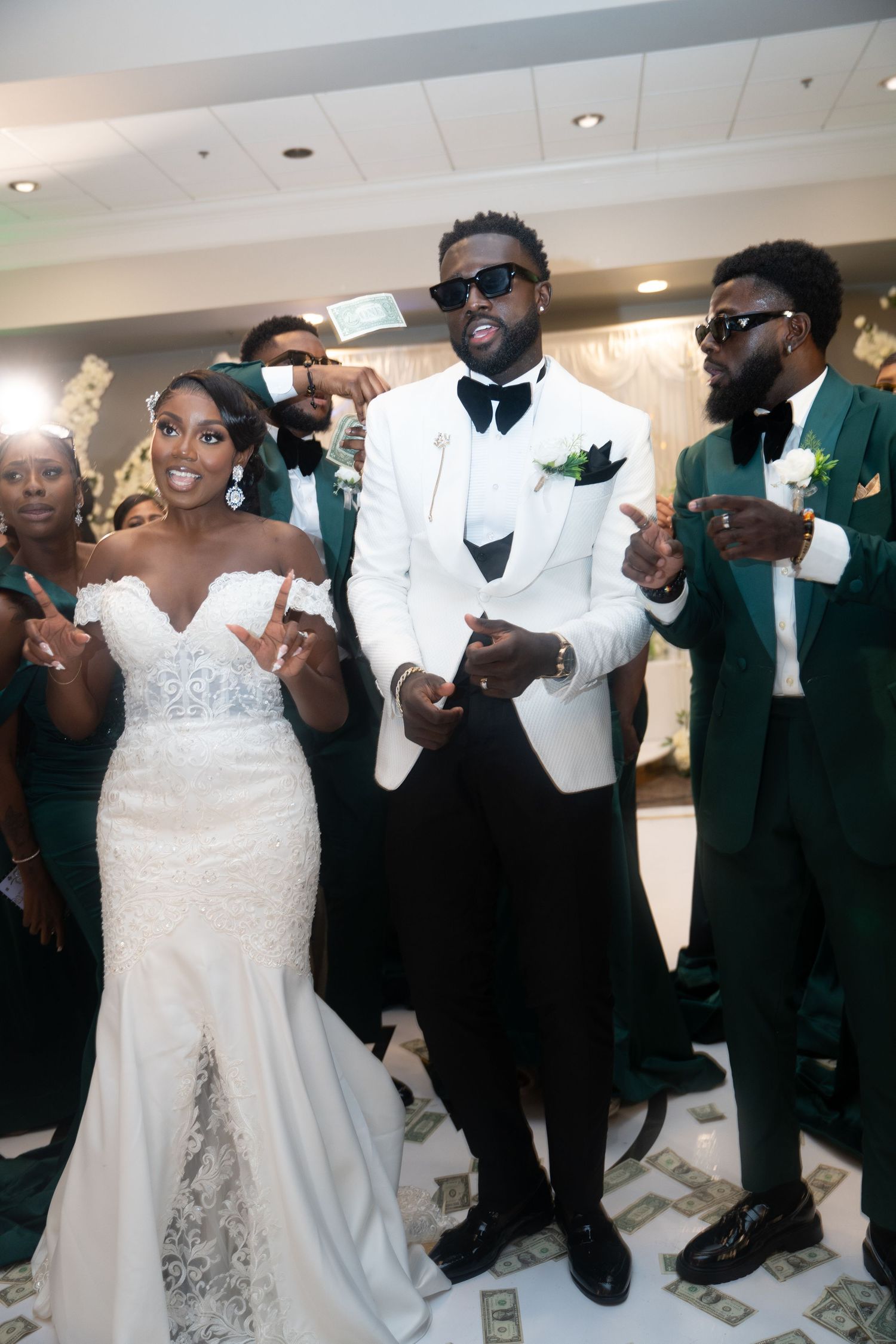 Wedding party in formal attire dancing and celebrating together in an indoor venue.