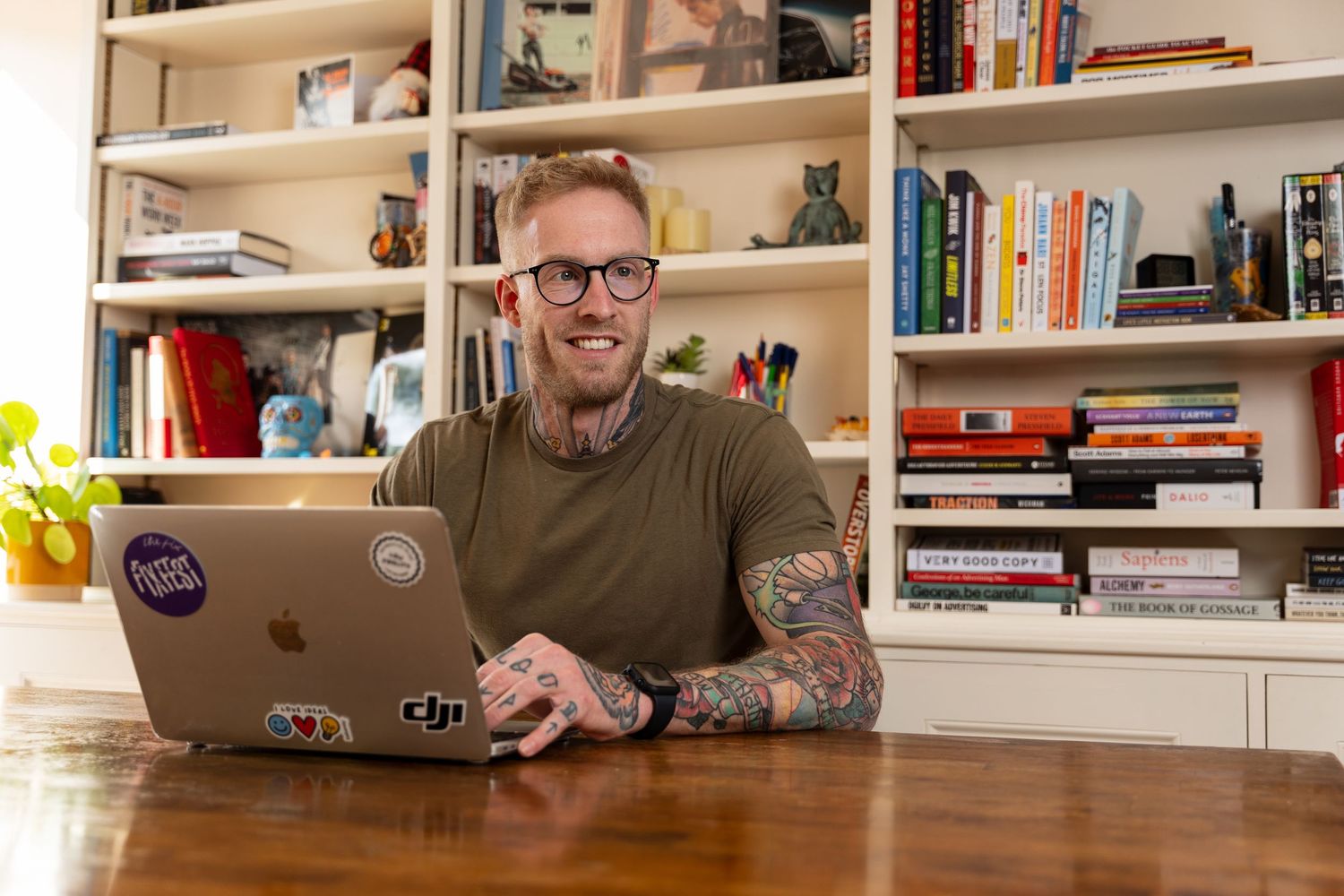 Winchester-based founder sits at his table with his laptop on his personal brand photoshoot.