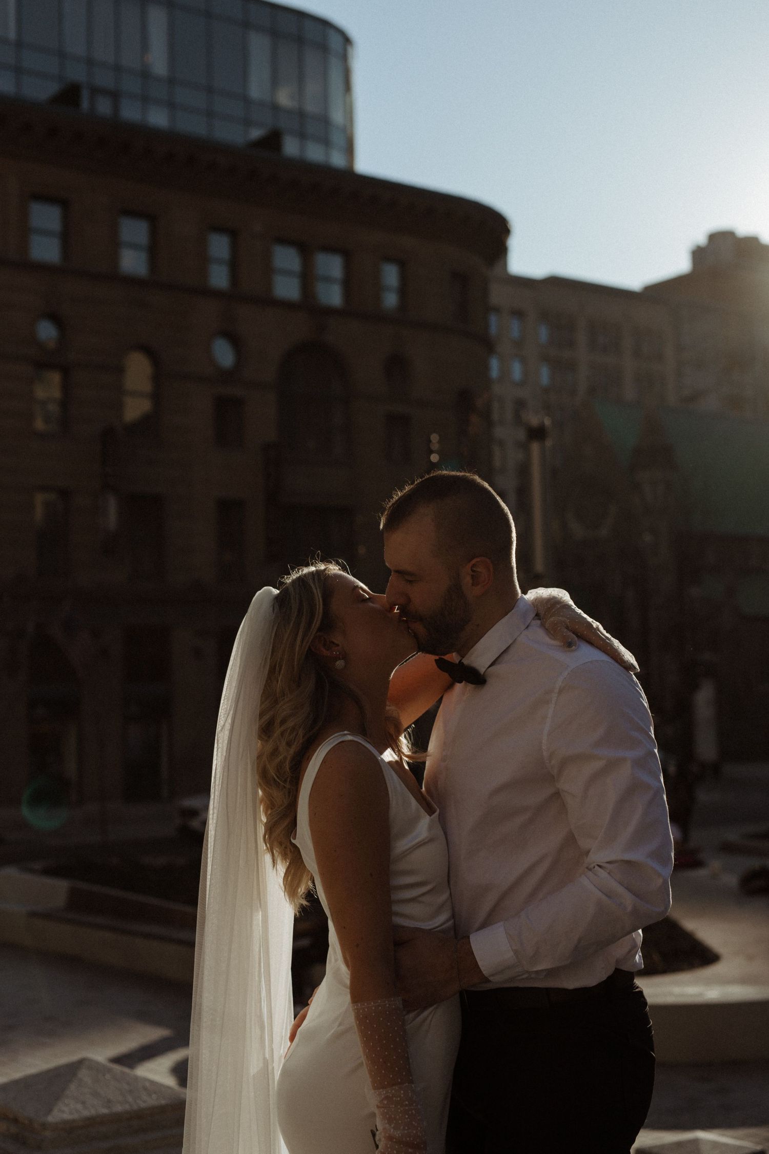 Futur mariés au centre-ville de Montréal lors du golden hour dans leurs vêtements de mariage