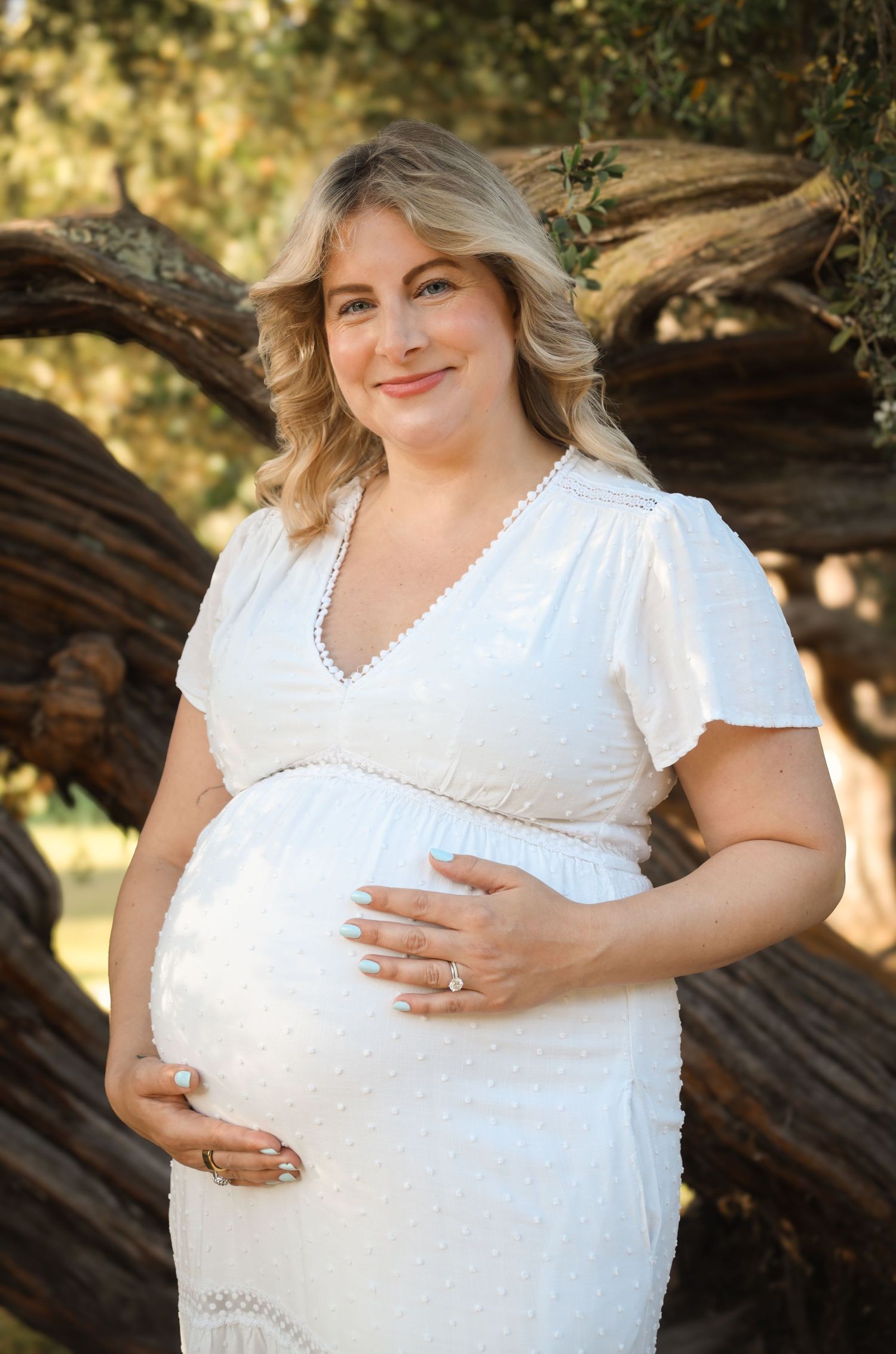 Soft, close-up portrait of an expectant mother holding her baby bump in golden hour light, natural maternity photography San Francisco.