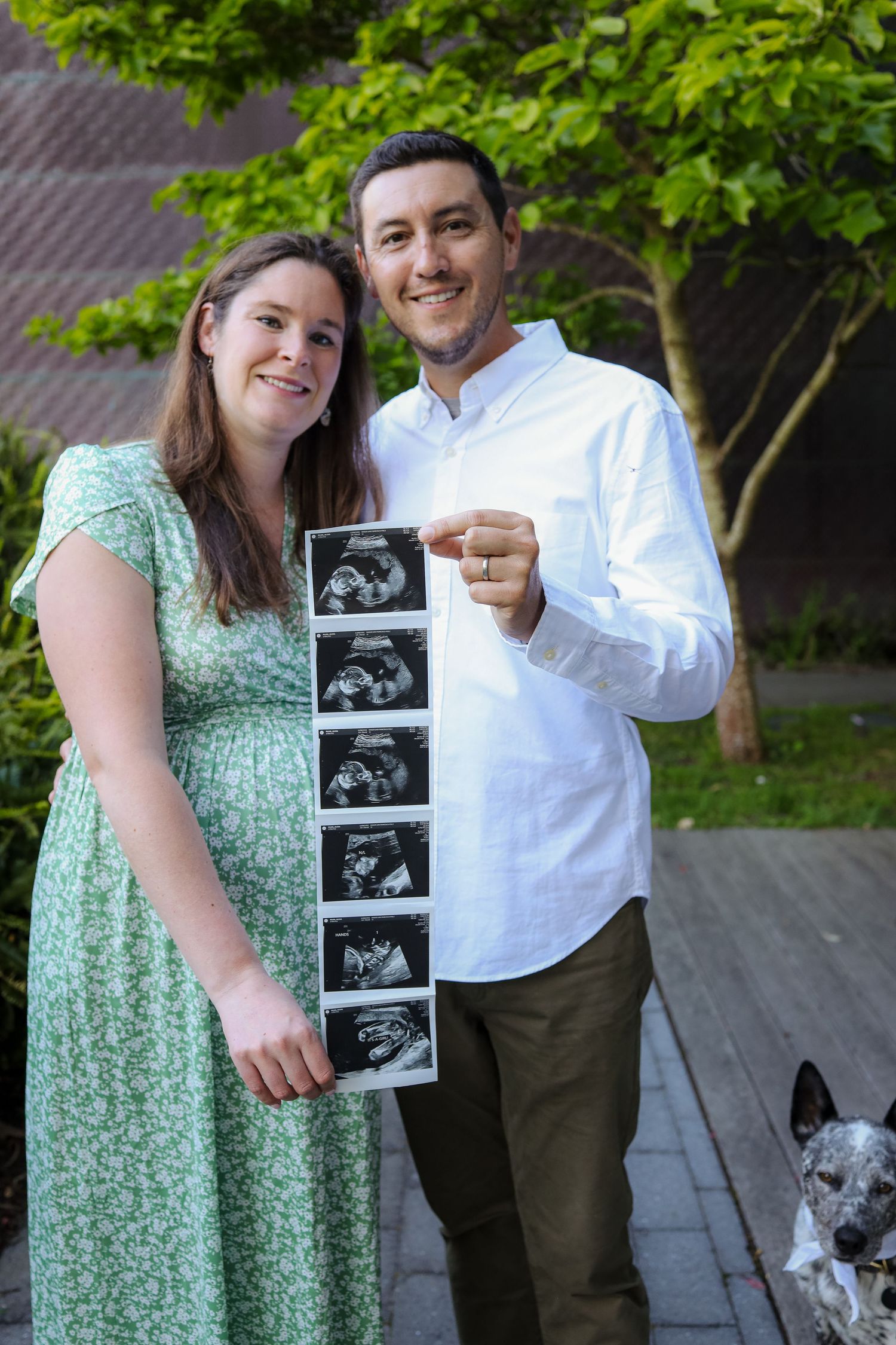 Close-up detail shot of expecting couple holding ultrasound sonogram strip in golden light, creative baby announcement photography in SF