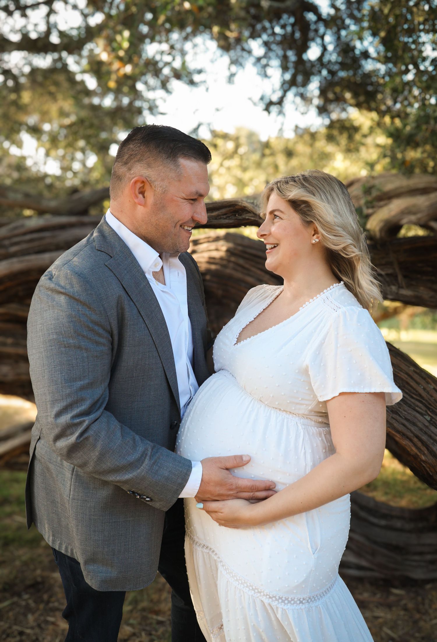 Soft, close-up portrait of couple, holding her baby bump in golden hour light, natural maternity photography San Francisco.
