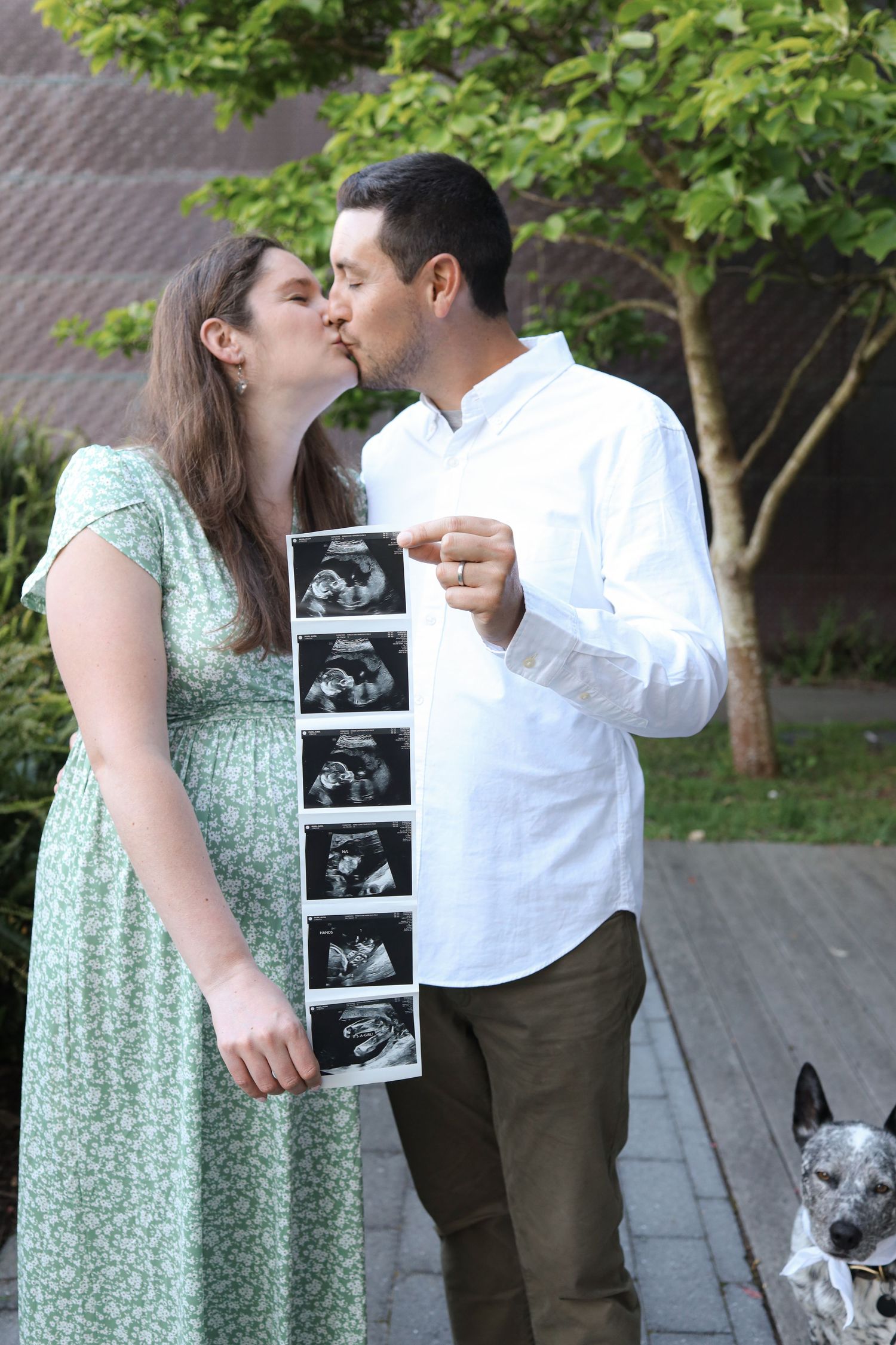 Close-up detail shot of expecting couple holding ultrasound sonogram strip in golden light, creative baby announcement photography in SF