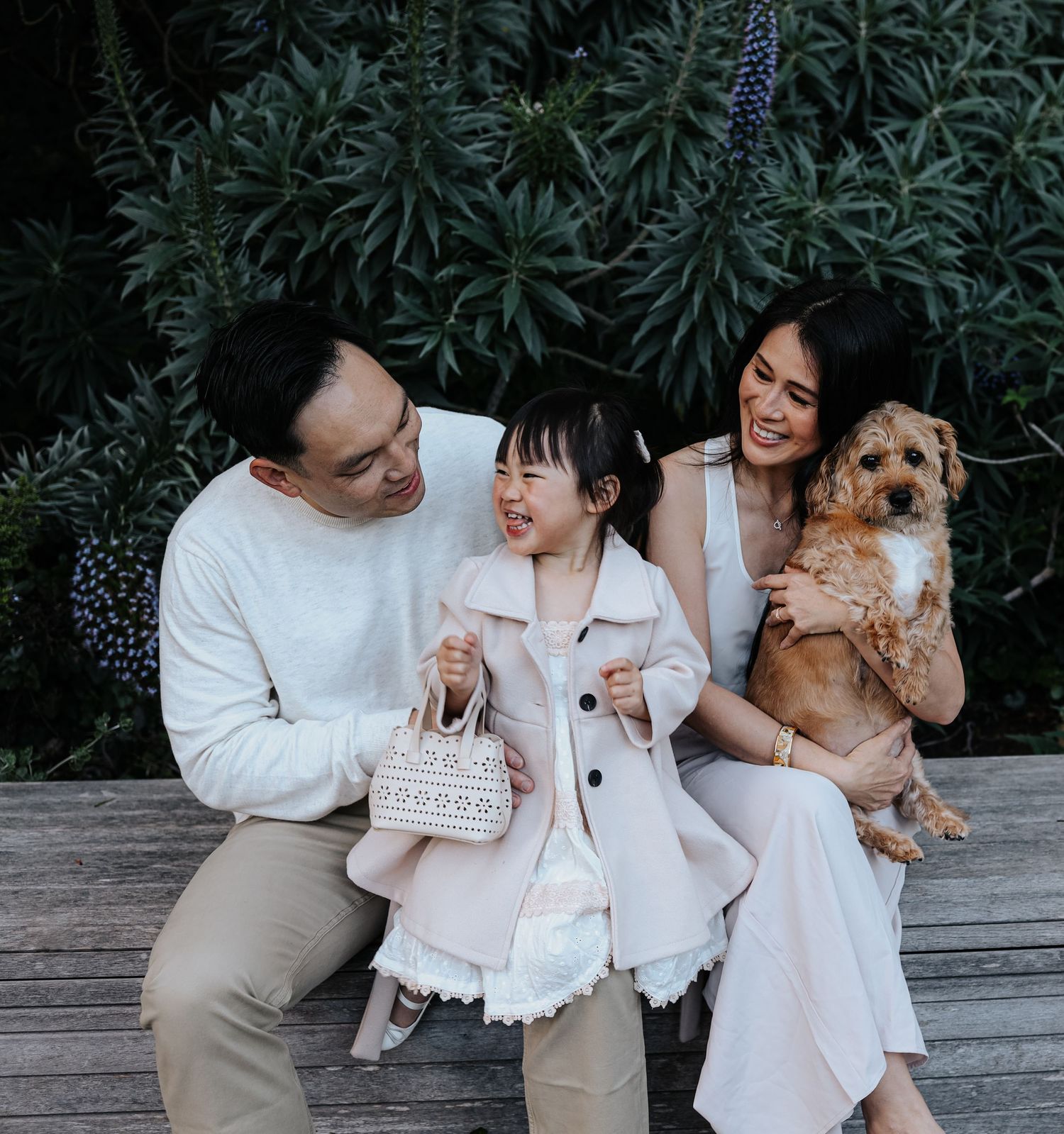 Soft natural light portrait of Father, mother and daughter cuddling their rescue dog in San Francisco pet-friendly photographer.