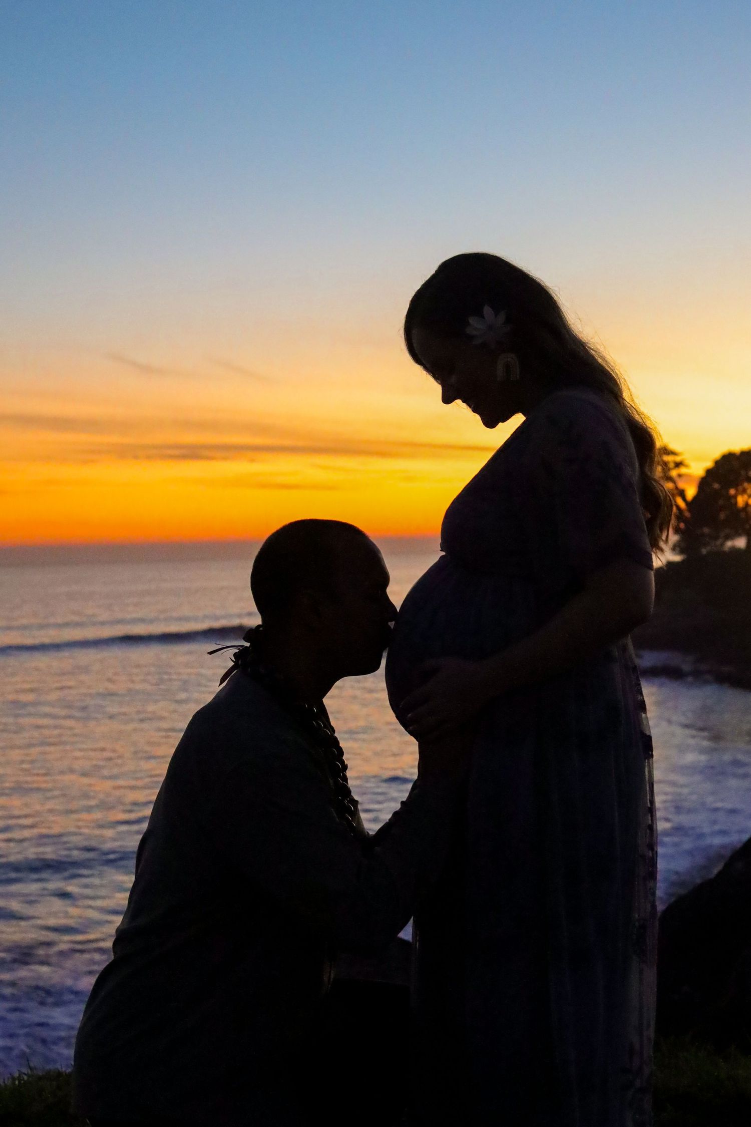Maternity silhouette by beach,