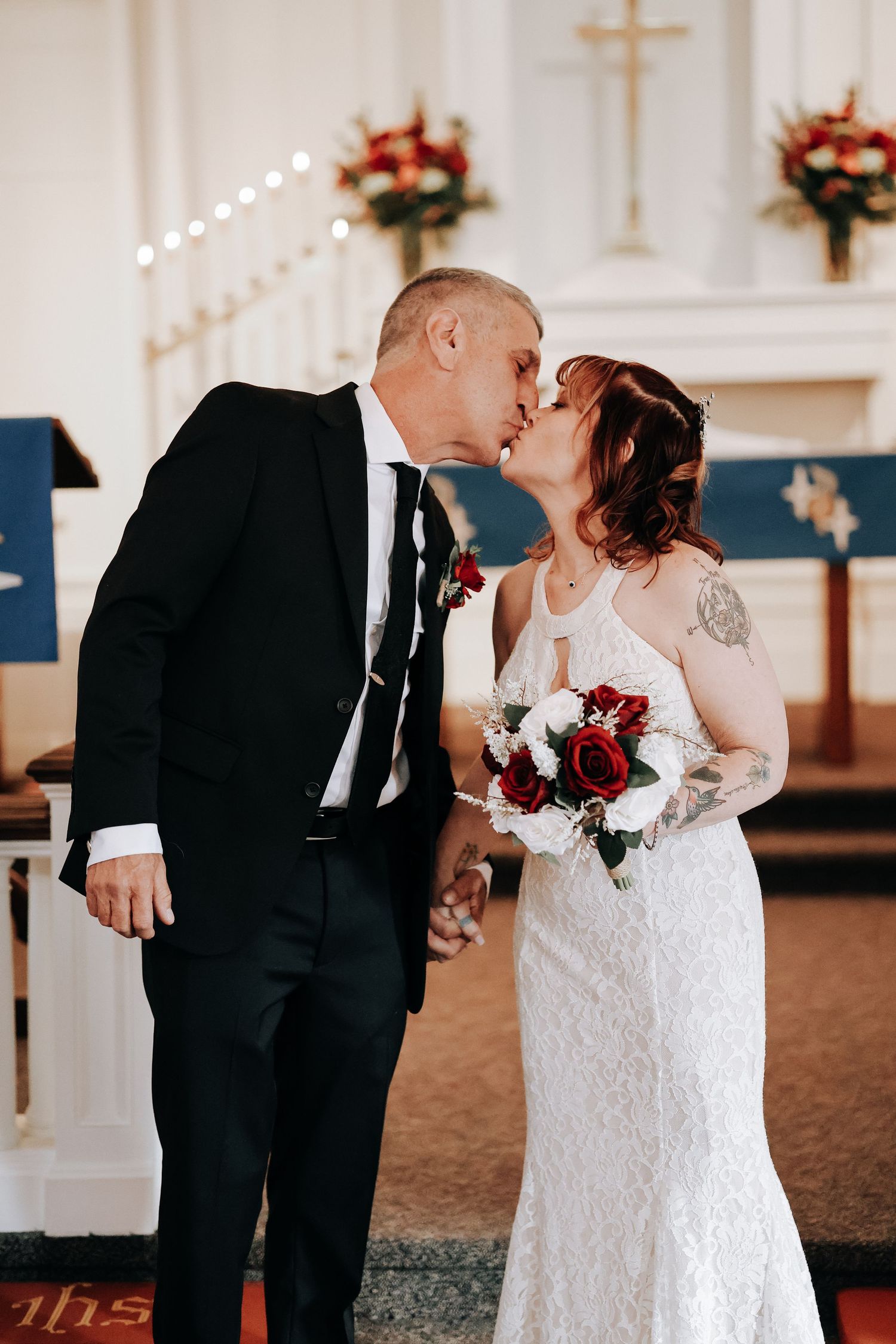 A romantic sequence of wedding photos showing a couple sharing a kiss in a church venue with white walls and red flowers.