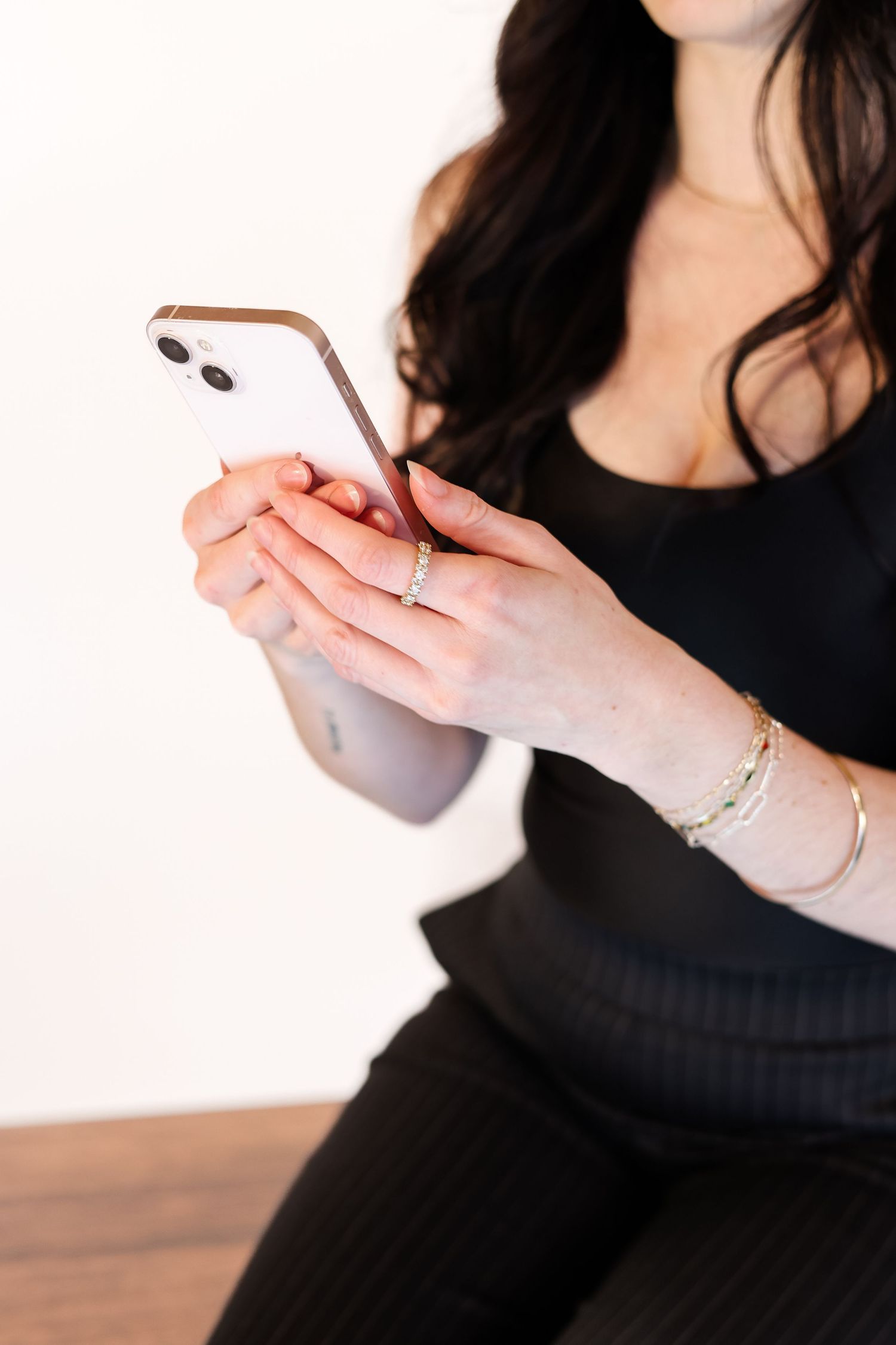 Woman in black top gestures with hands while holding pen during business presentation or meeting.