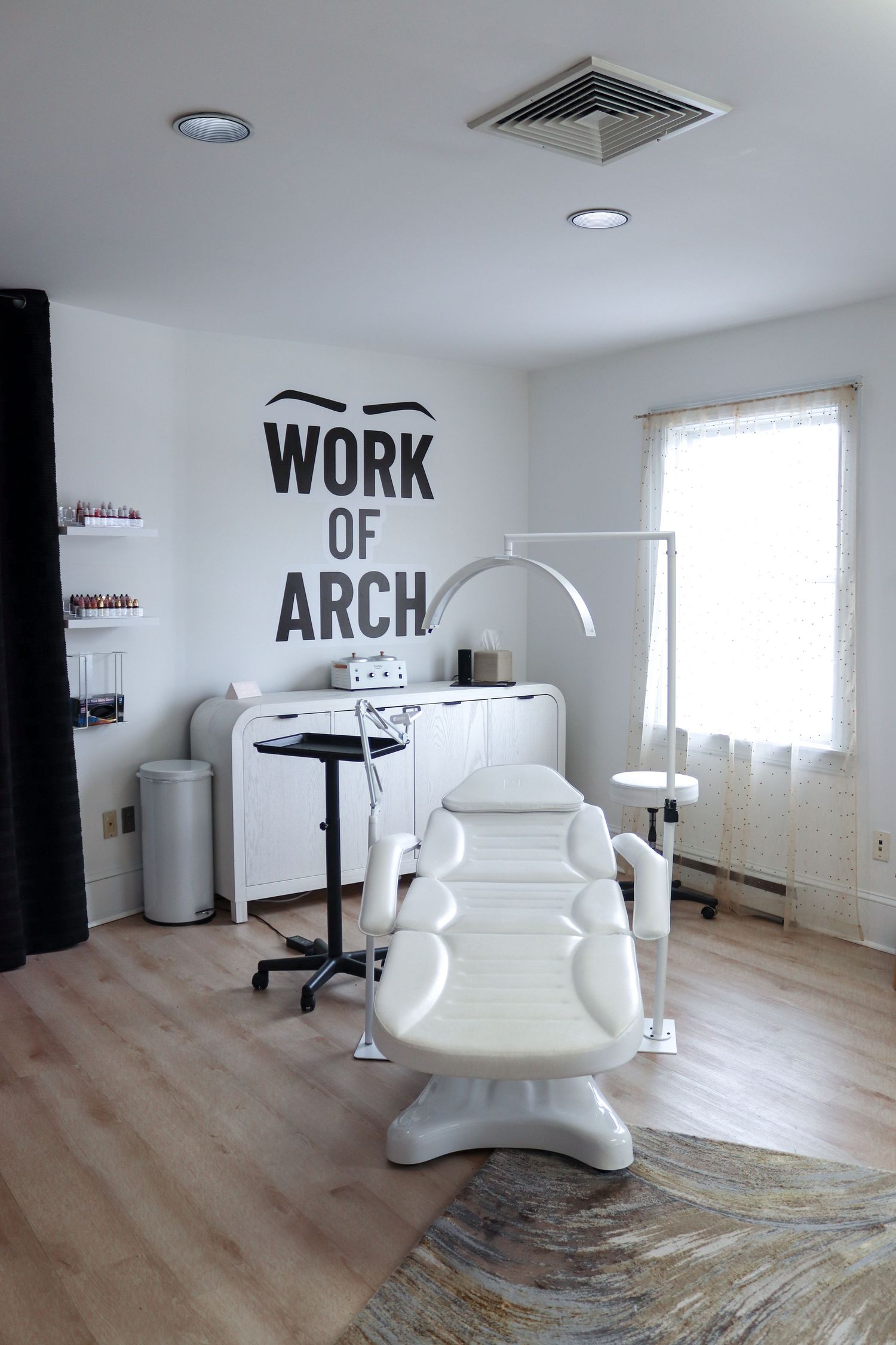 A modern white salon interior with minimalist decor and styling chairs arranged in a bright space.