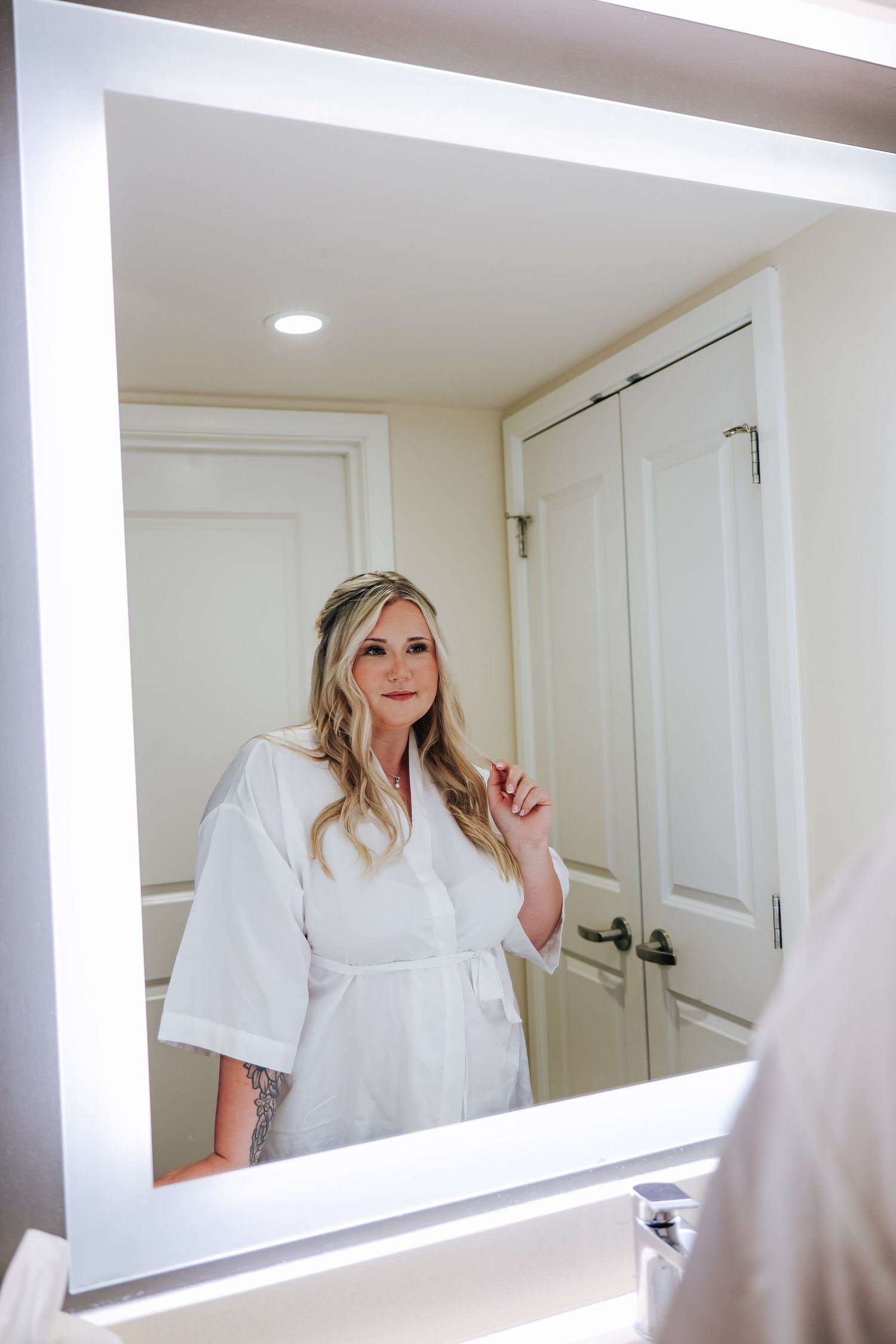 Solo bridal portrait of the bridge looking at her reflection in mirror