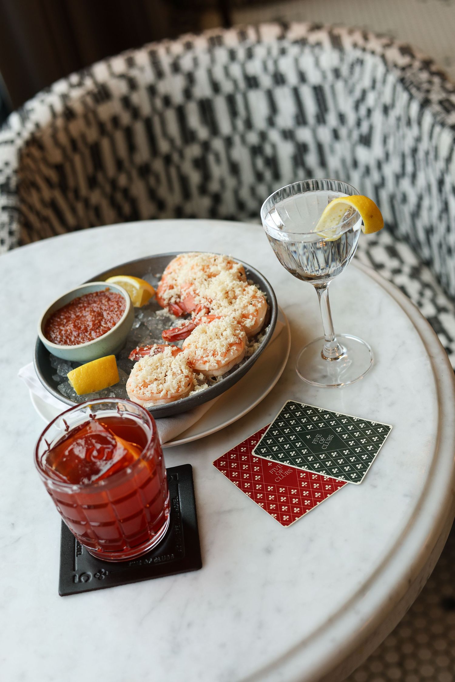 A series of cocktail glasses and appetizers on a white textured surface with red and green napkins.