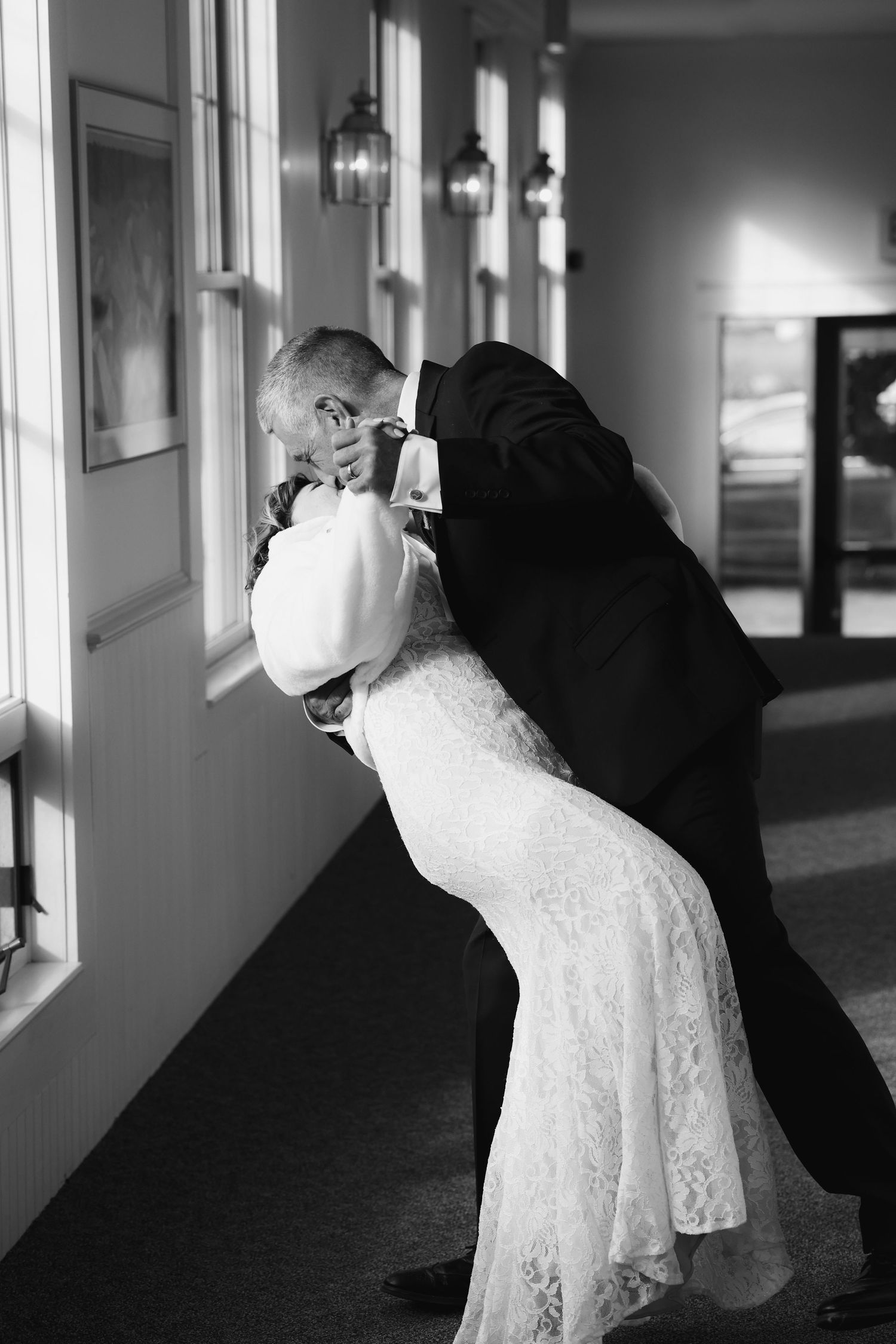 A series of black and white photos showing a couple in formal attire dancing in a dimly lit hallway.
