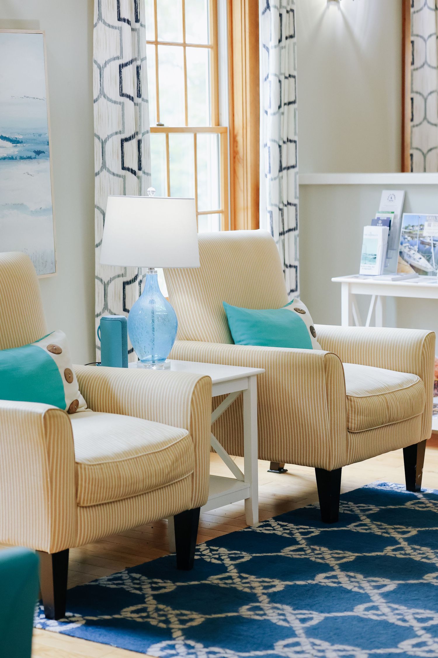 Modern living room interior with cream chairs and blue geometric rug for hotel marketing in Maine