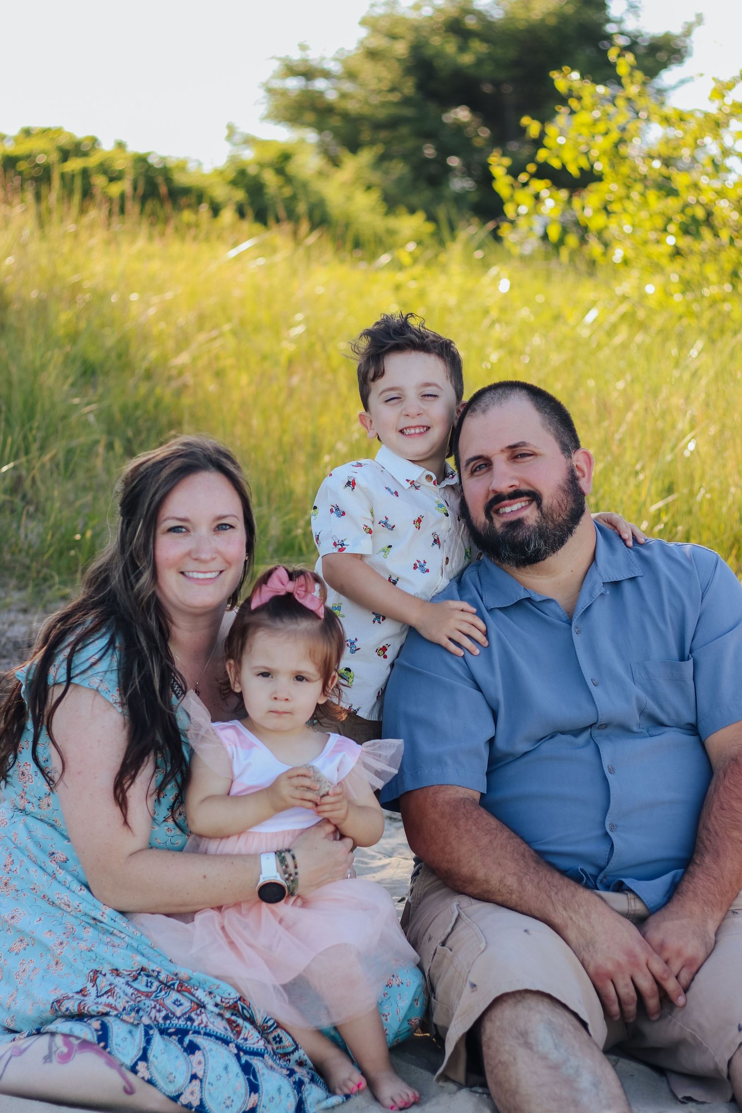Family portrait session in a sunny meadow with bright light.