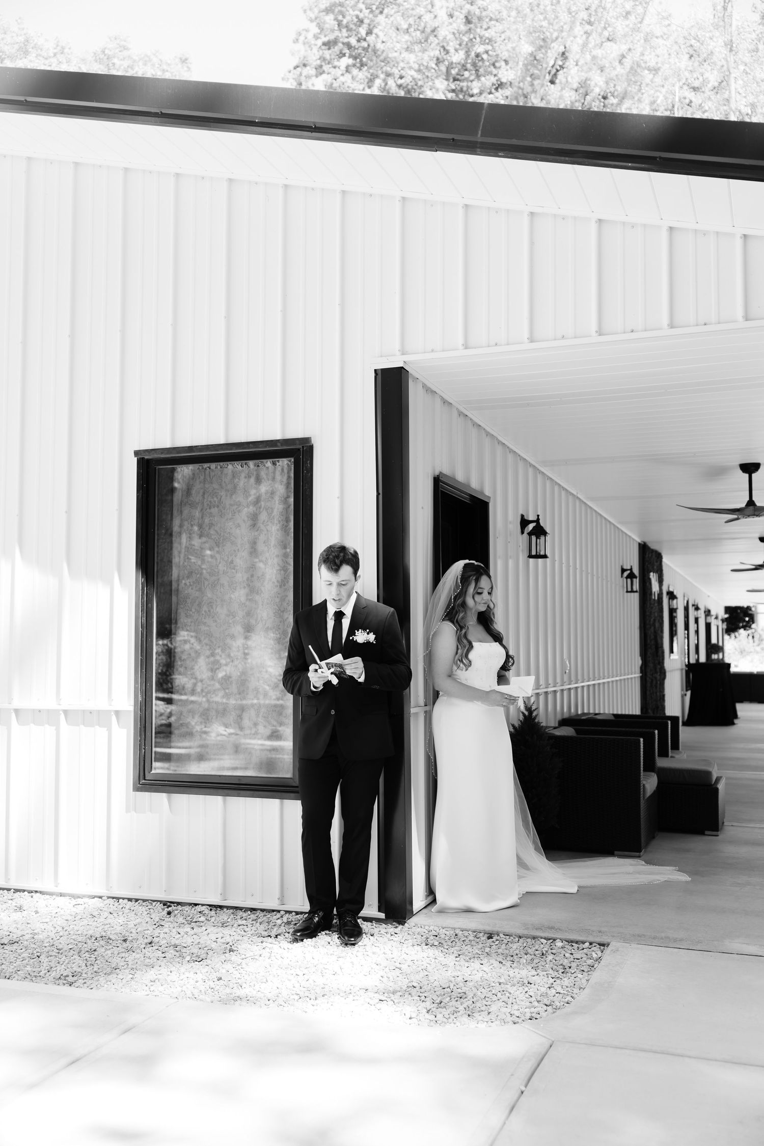 Black and white series showing a couple's first look moments outside a white building.