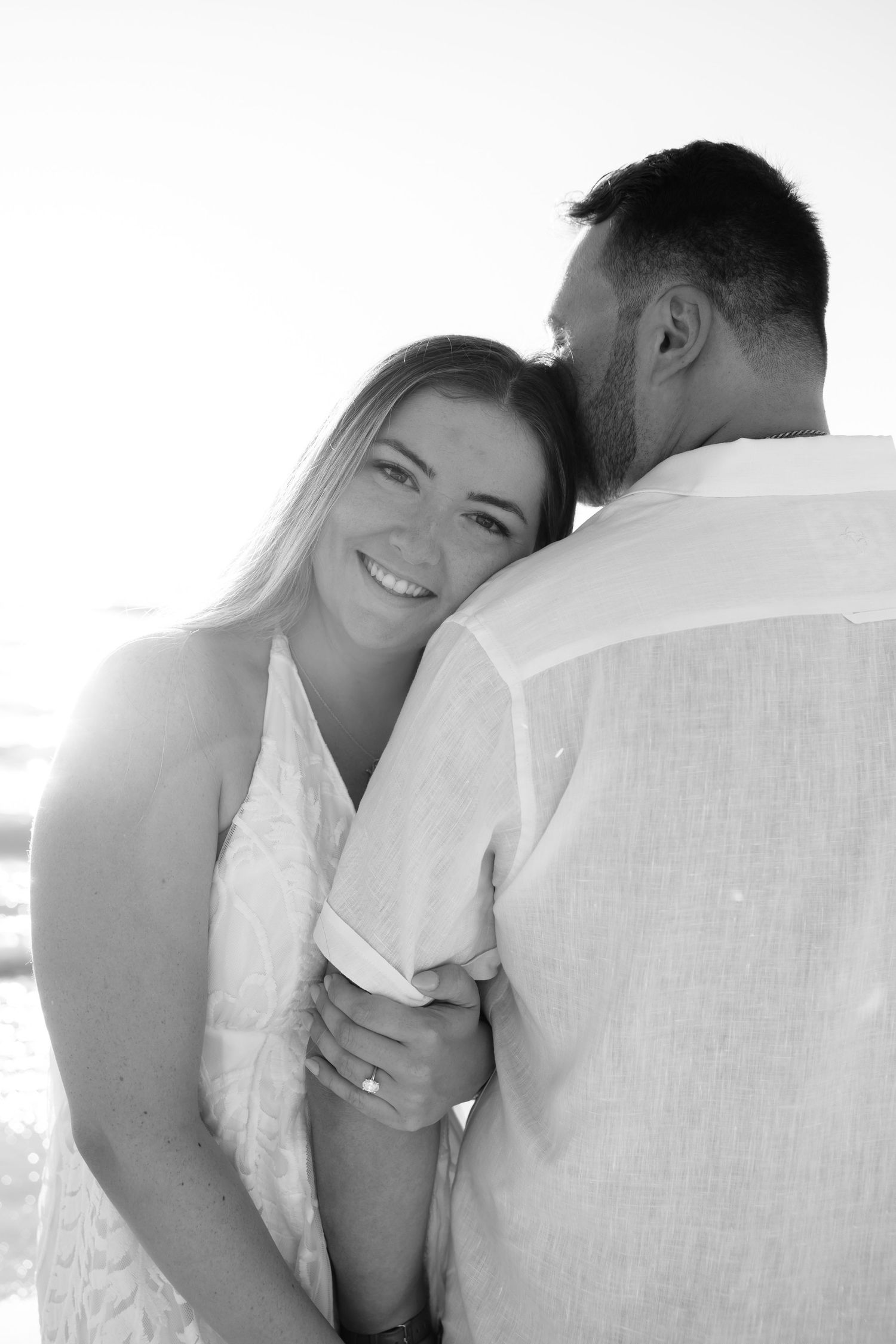 A romantic black and white photo series showing tender moments between a couple in white clothing.