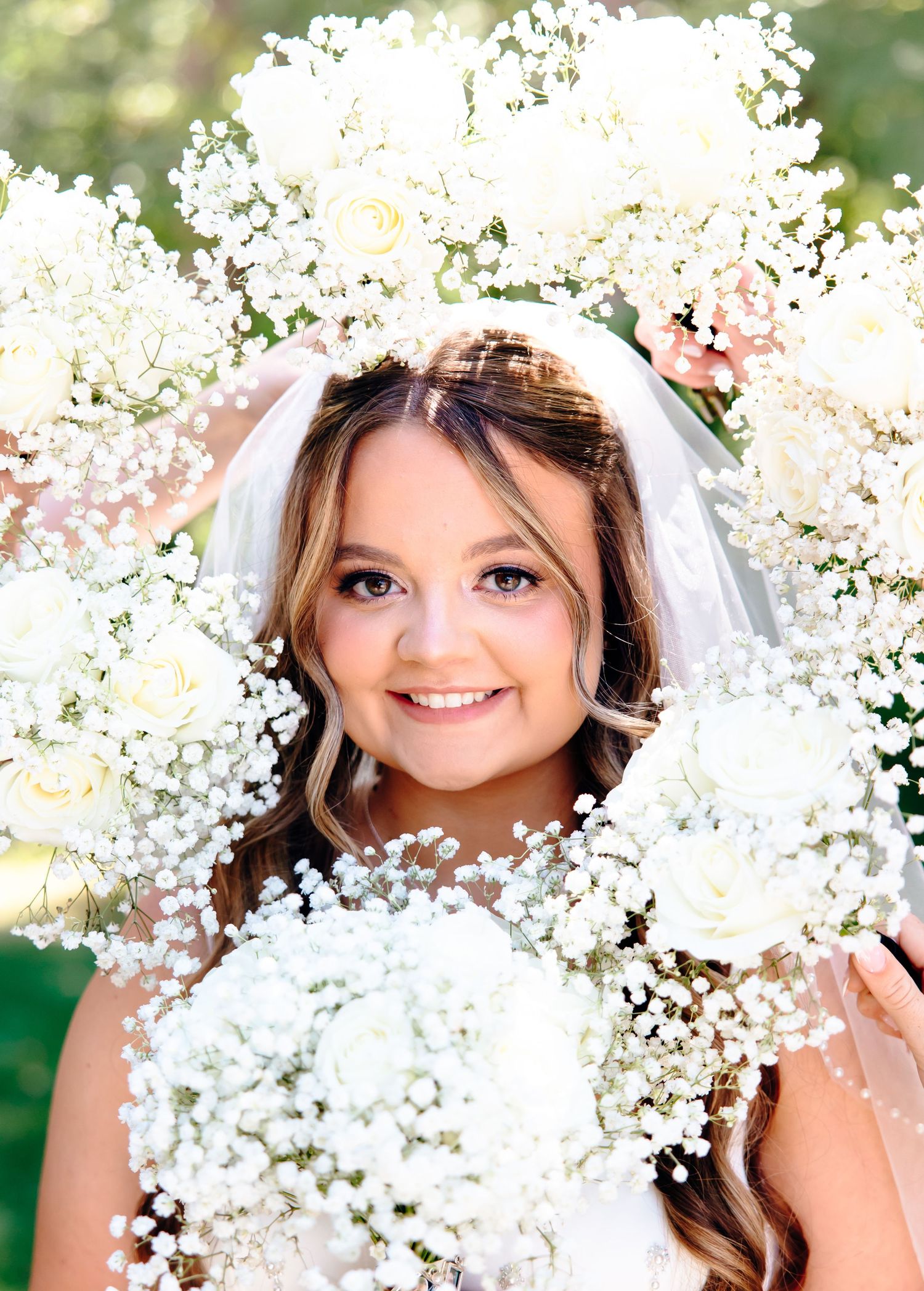 Delicate baby's breath flowers frame a bridal portrait with floral crown.