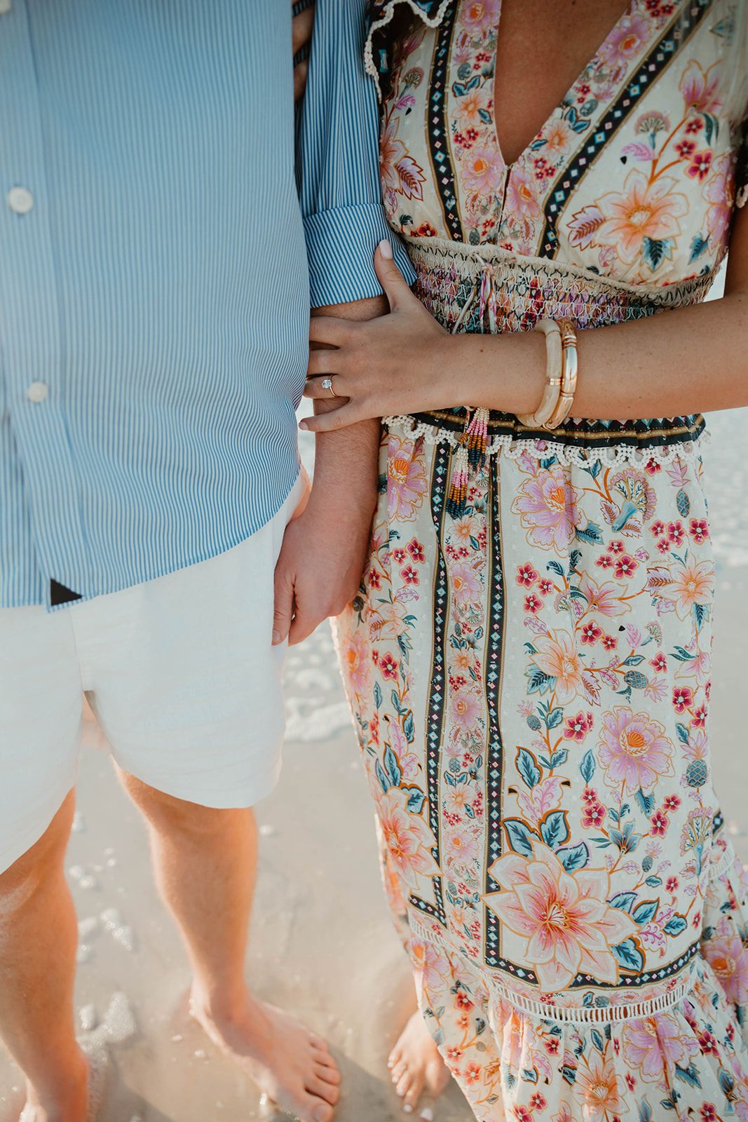 Detail shots of a couple's outfits showing a floral dress and blue shirt against beach backdrop.