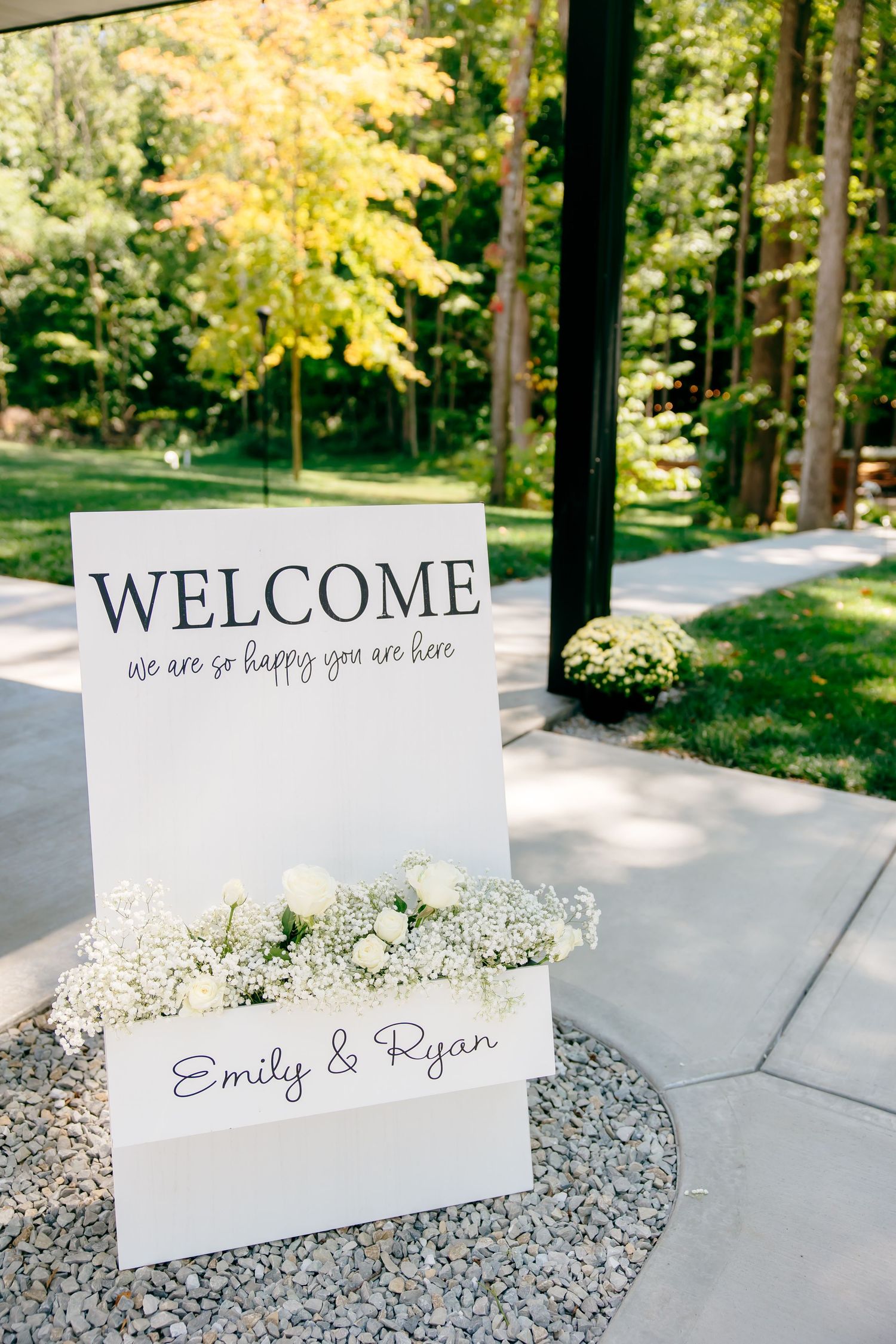 Welcome signs with floral decorations displayed along a garden pathway.