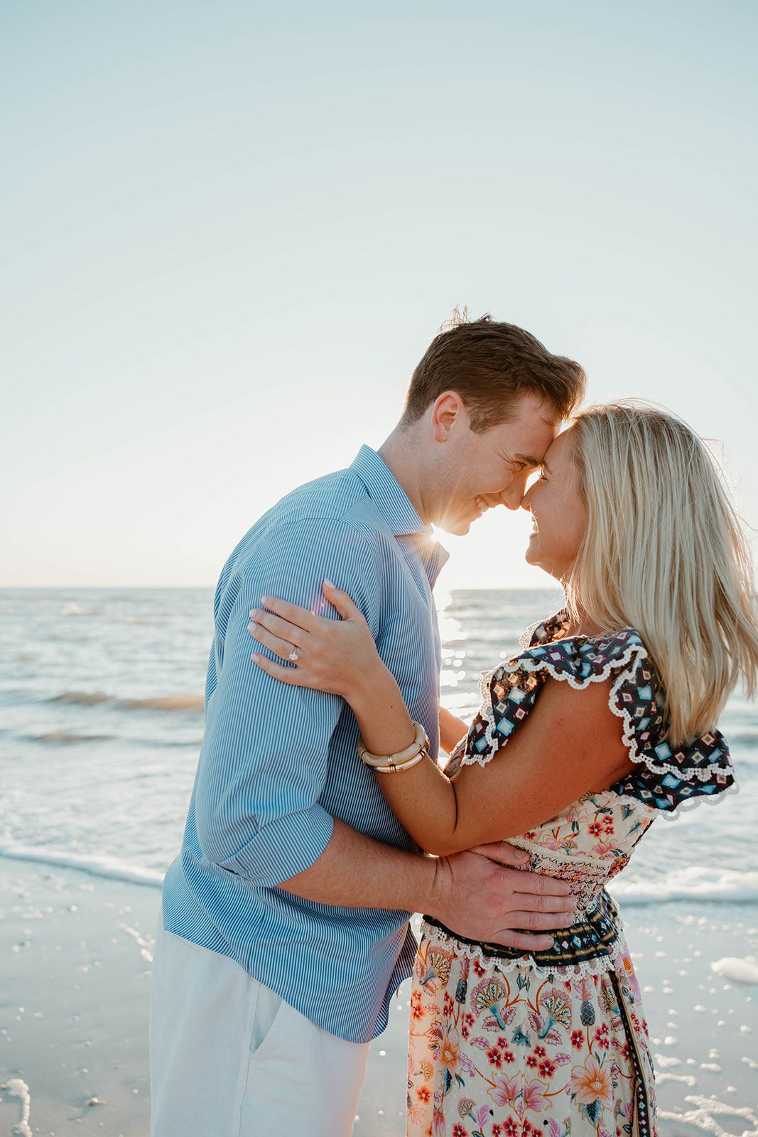 An intimate embrace between a couple on the beach after getting engaged.