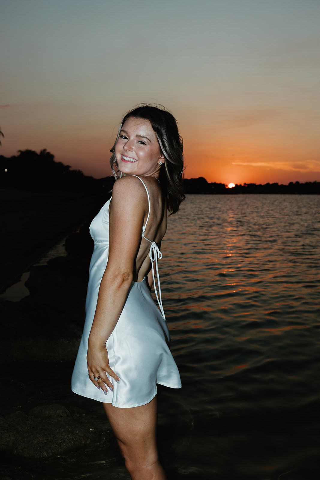 Sunset beach photoshoot with water reflections and warm evening light.