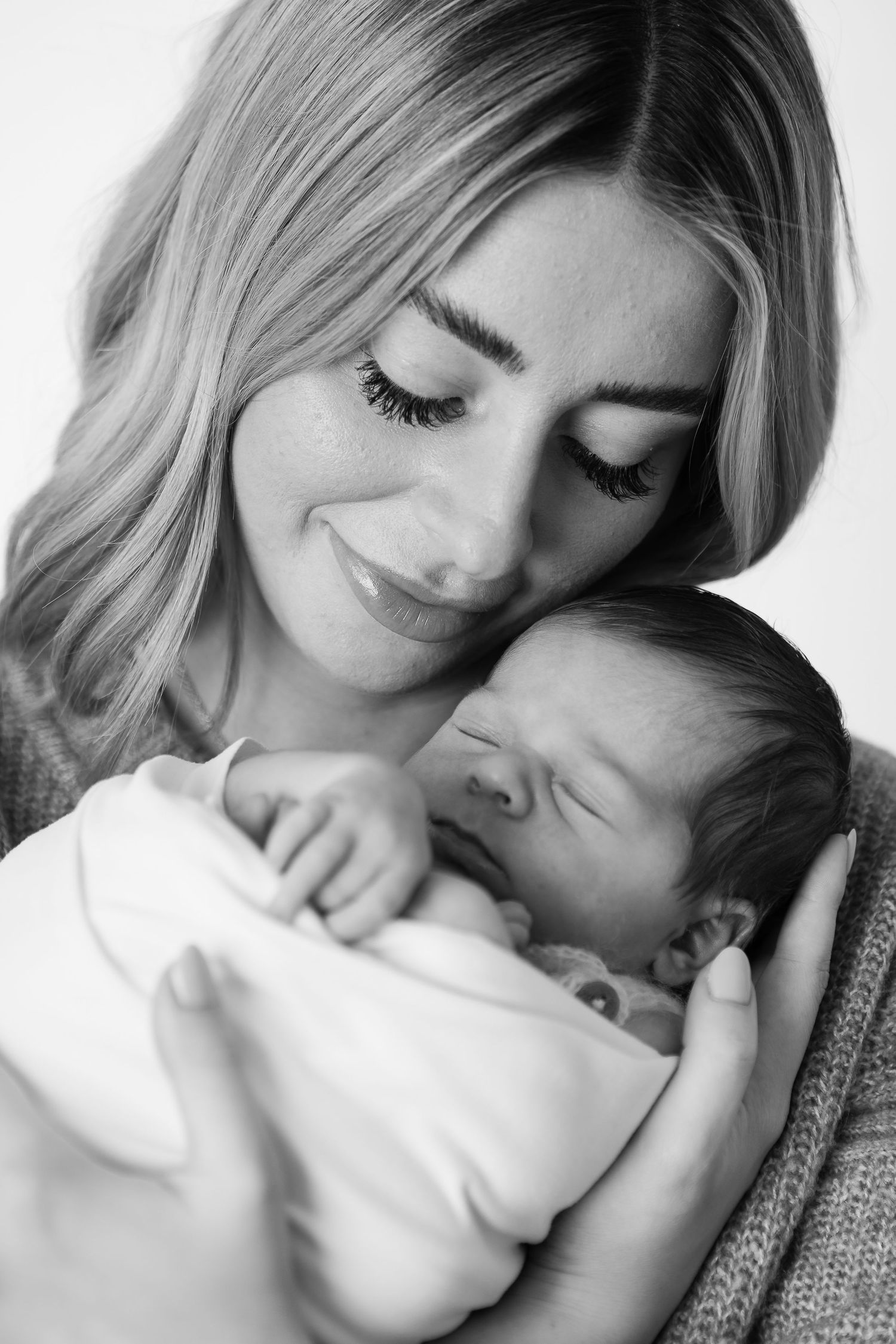 Black and white intimate portraits showing tender moments between parent and baby.