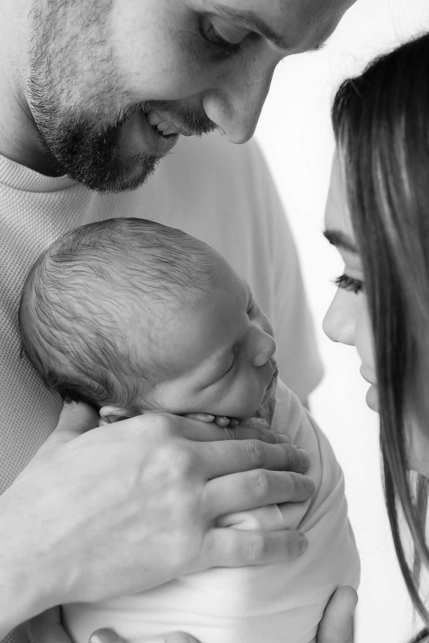 Black and white series showing parents sharing tender moments with their newborn.