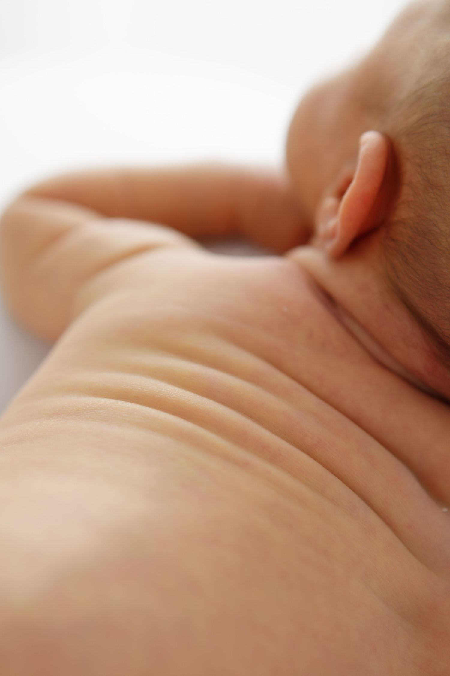Peaceful sleeping newborn photographed in soft natural lighting.