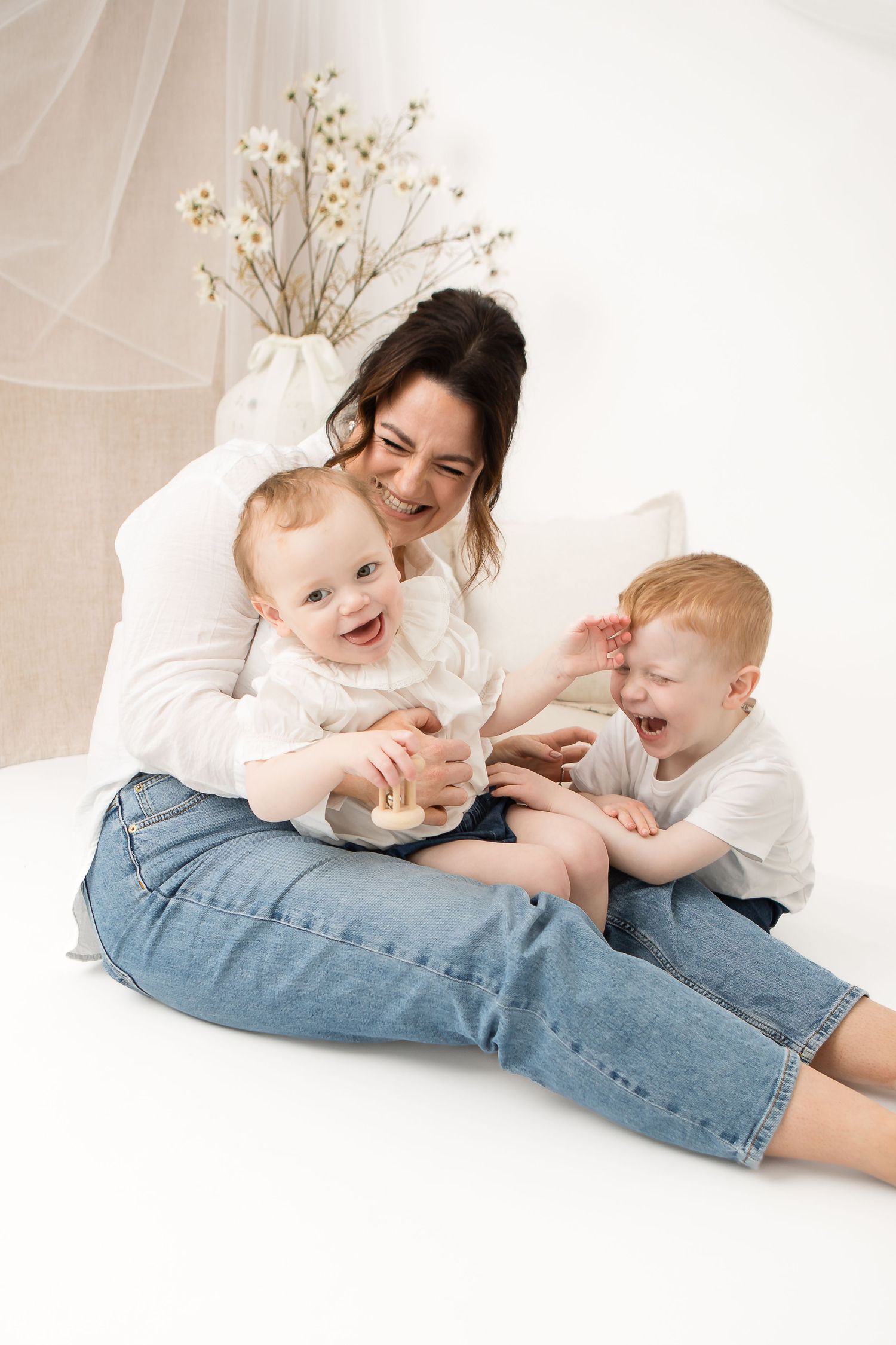 Joyful parent and child playing together on white floor.