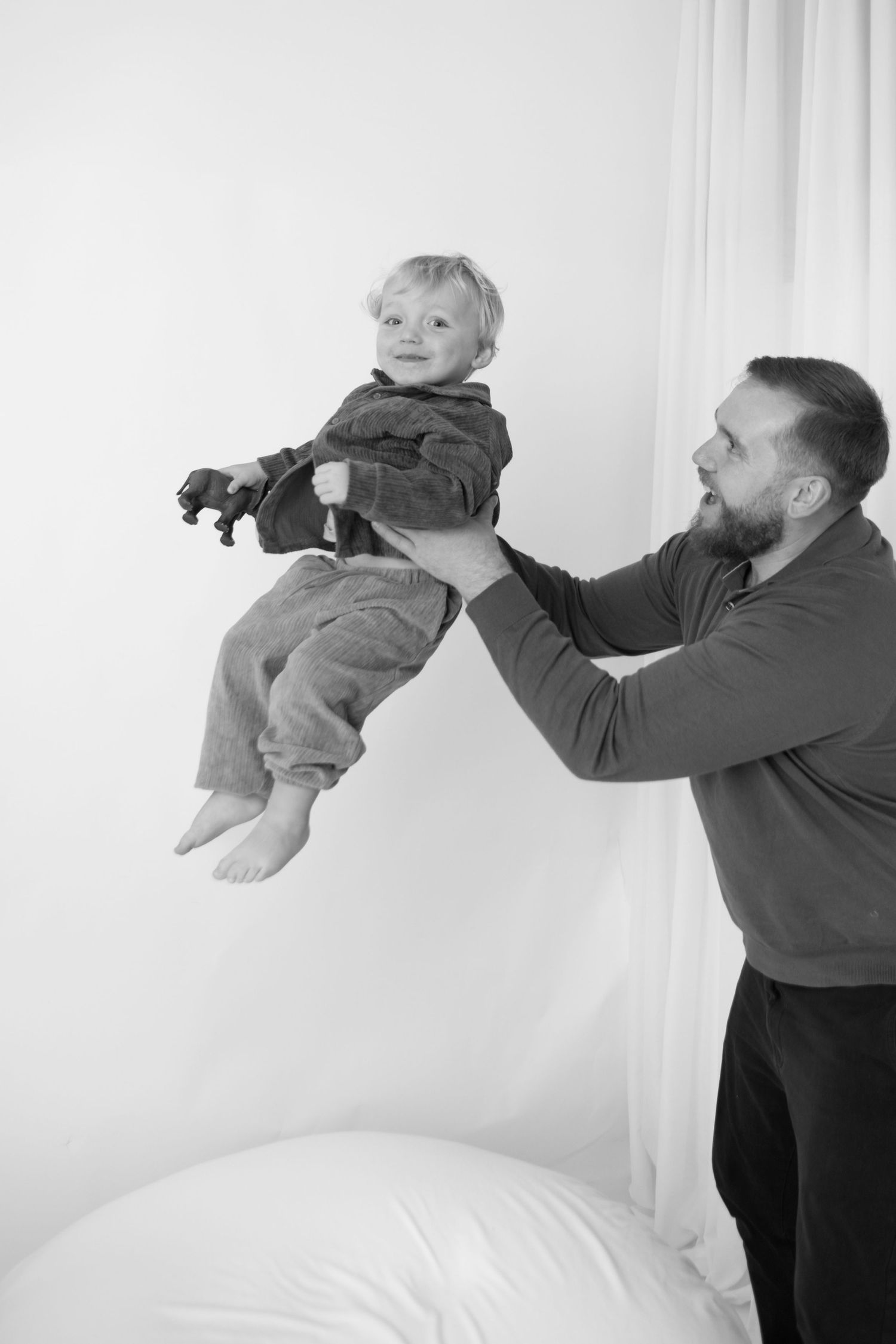 Sequence of playful lifting poses in black and white studio setting.
