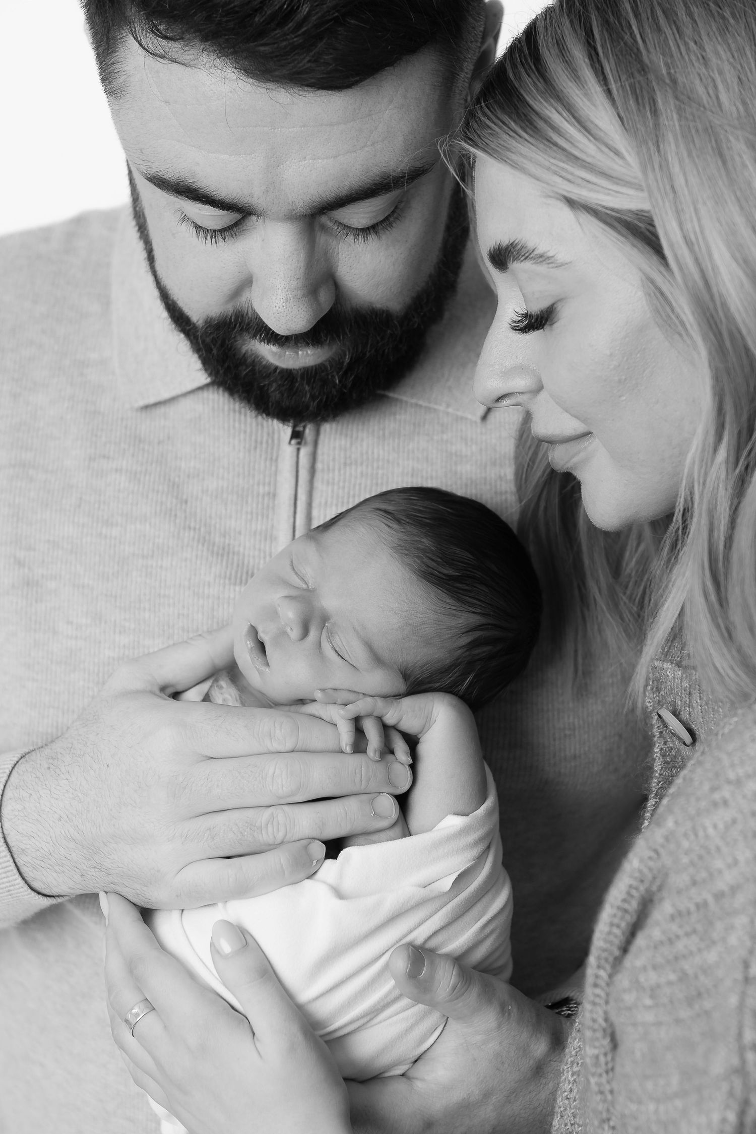 Loving black and white family portraits showing tender moments with a newborn.