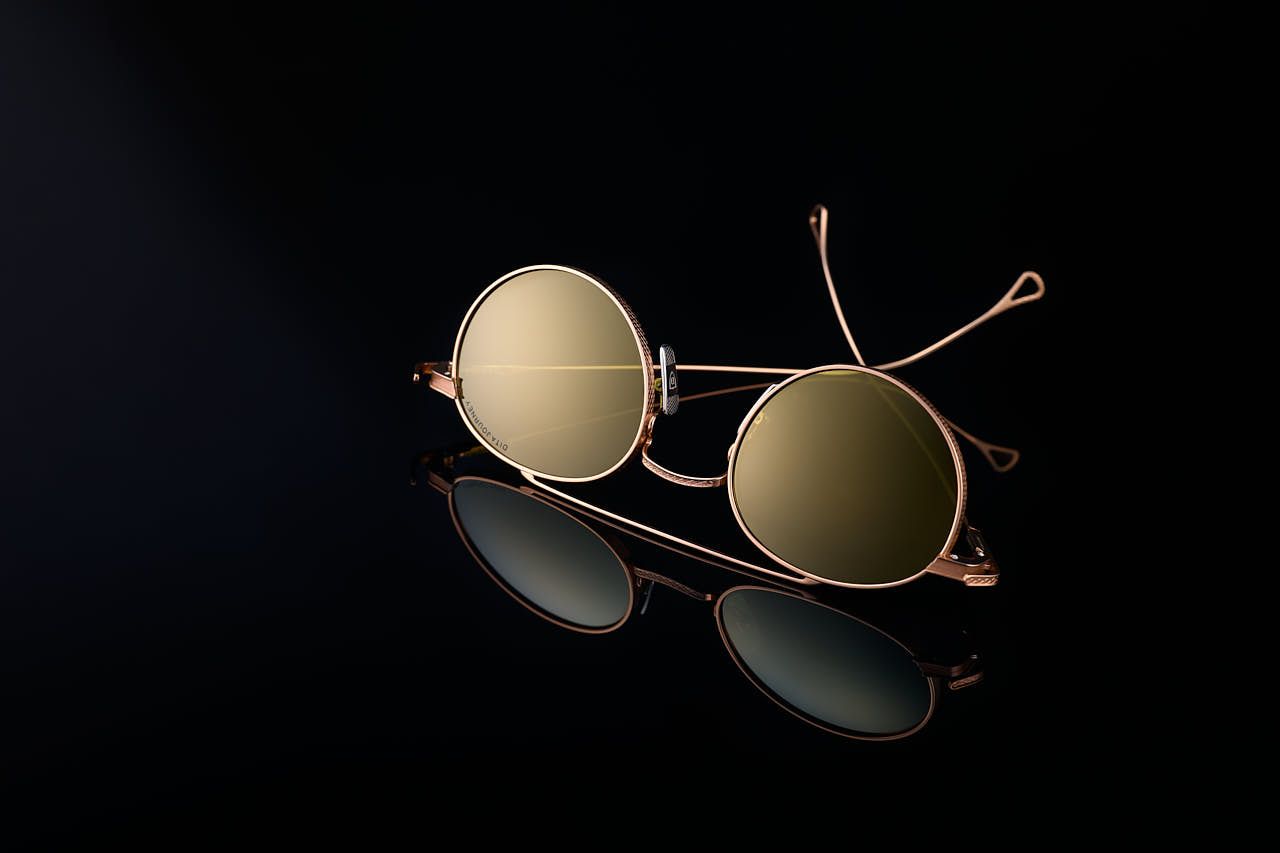 Photographe produits Yvelines - Lunettes soleil haut de gamme sur fond noir avec reflets - Studio professionnel