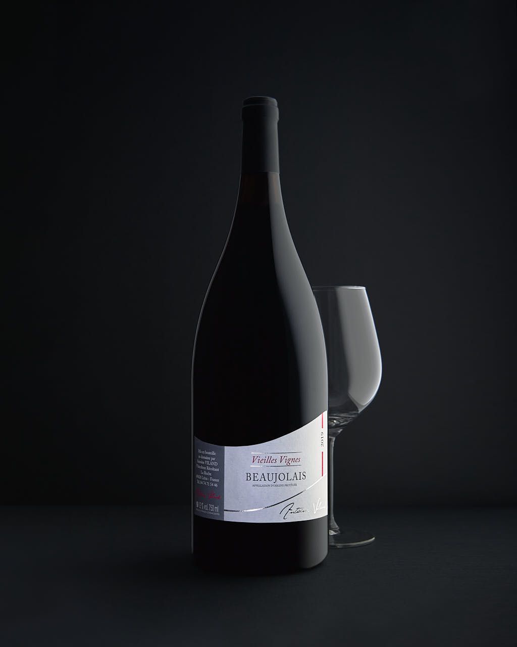 Photographe produits Yvelines - Magnum Beaujolais Antoine Viland avec verre sur fond noir - Studio professionnel
