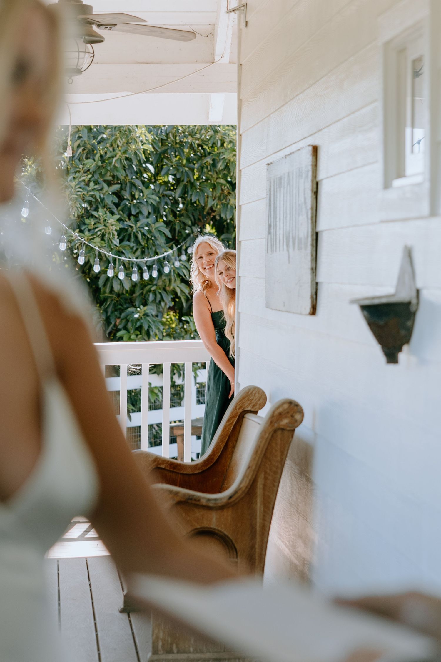 Soft focus interior shot of a white porch with string lights and natural decor.