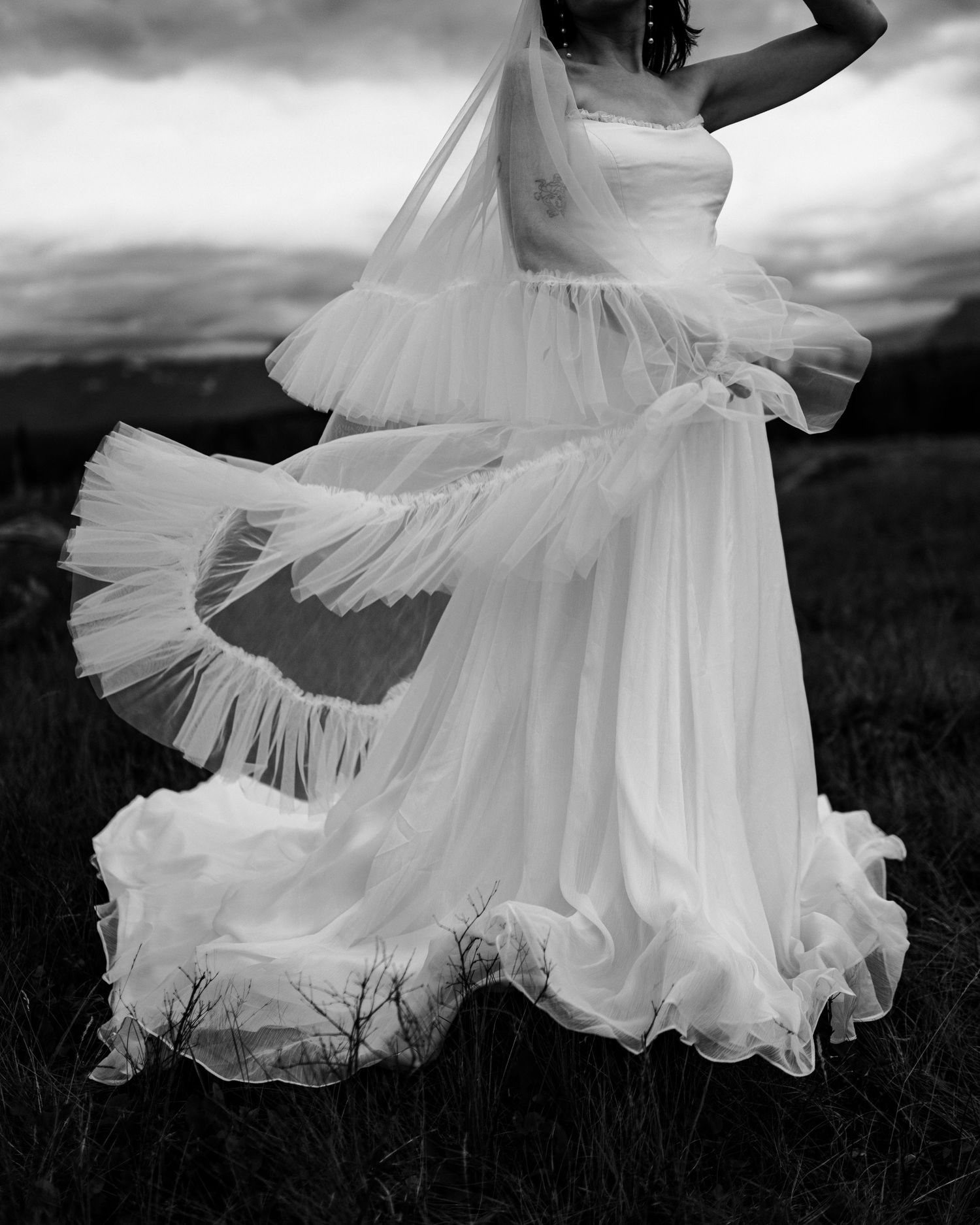 Black and white photo of a wedding dress twirling in dramatic motion.