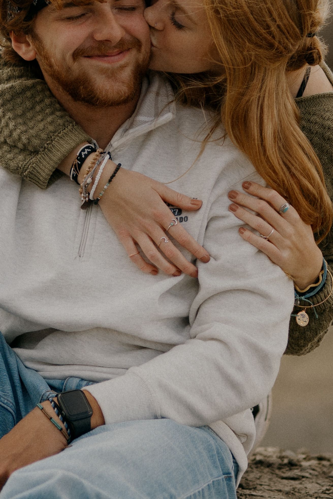 Intimate moment between couple wearing cozy sweaters and jeans.
