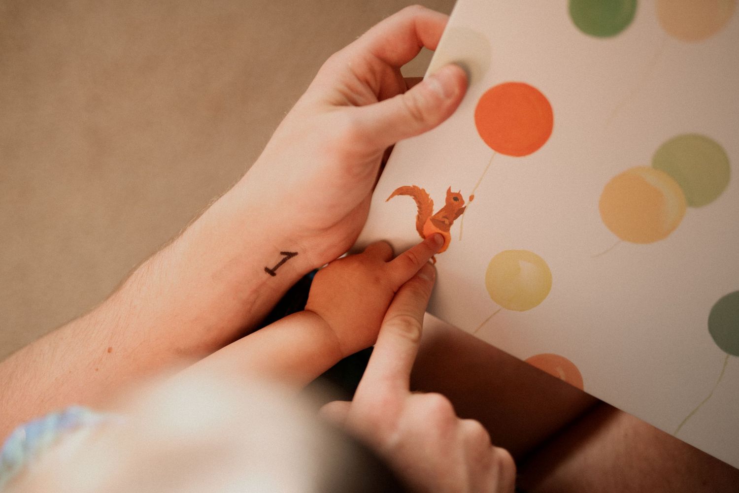 Close-up view of hands making finger heart shapes against a polka dot patterned background.