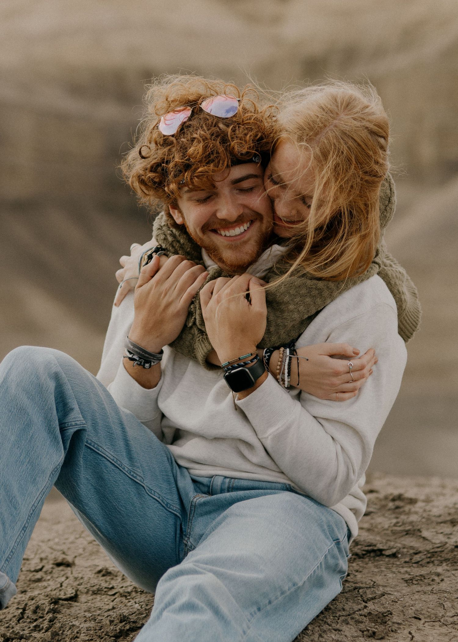 An engaged couple embrace in the Utah desert.