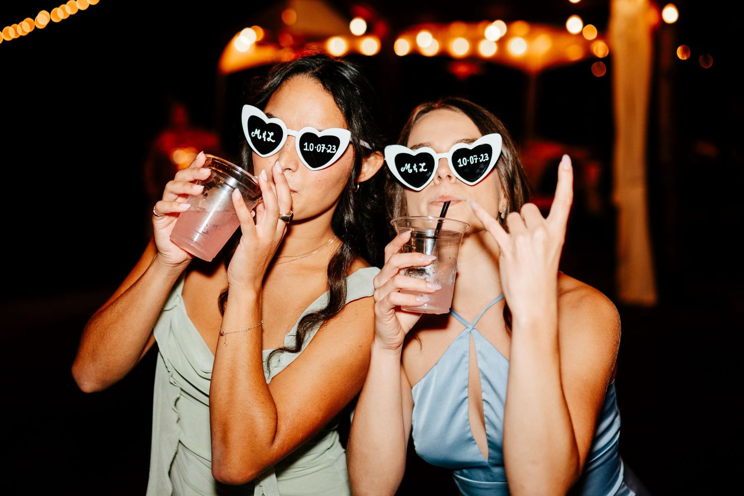 Reception guests pose with heart-shaped sunglasses in a fun reception photo.